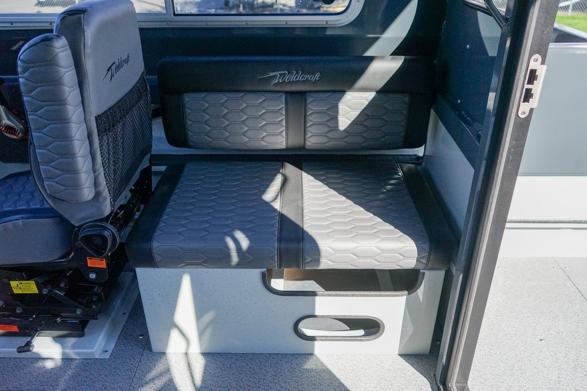 Interior seating of 2026 Weldcraft 210 Revolution boat, featuring gray cushioned seats.