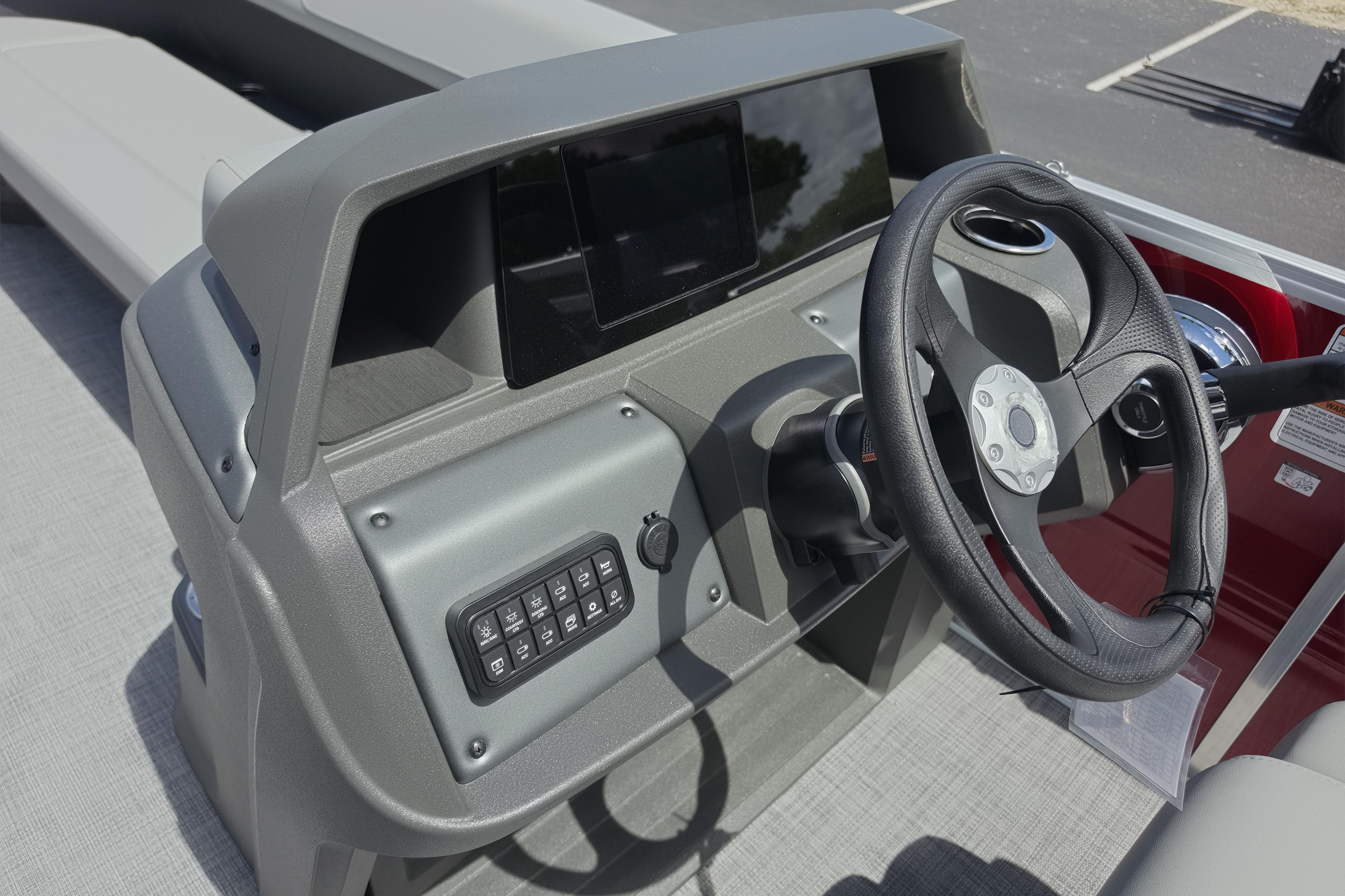 2026 Sun Tracker Party Barge 18 DLX dashboard with steering wheel and control panel.