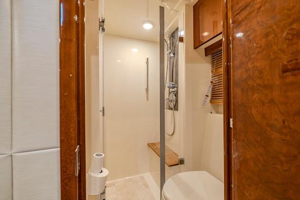 Luxurious bathroom interior of 2016 Sea Ray Sundancer 510 yacht with wooden accents.