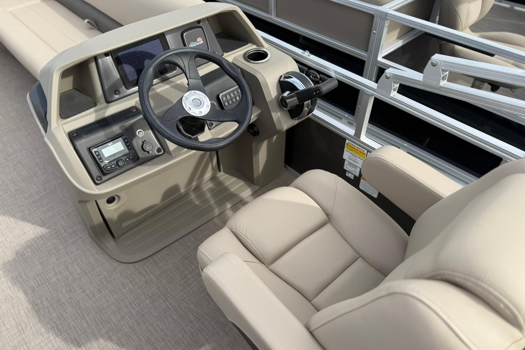 2025 Sun Tracker Party Barge 18 DLX helm with steering wheel and control panel.