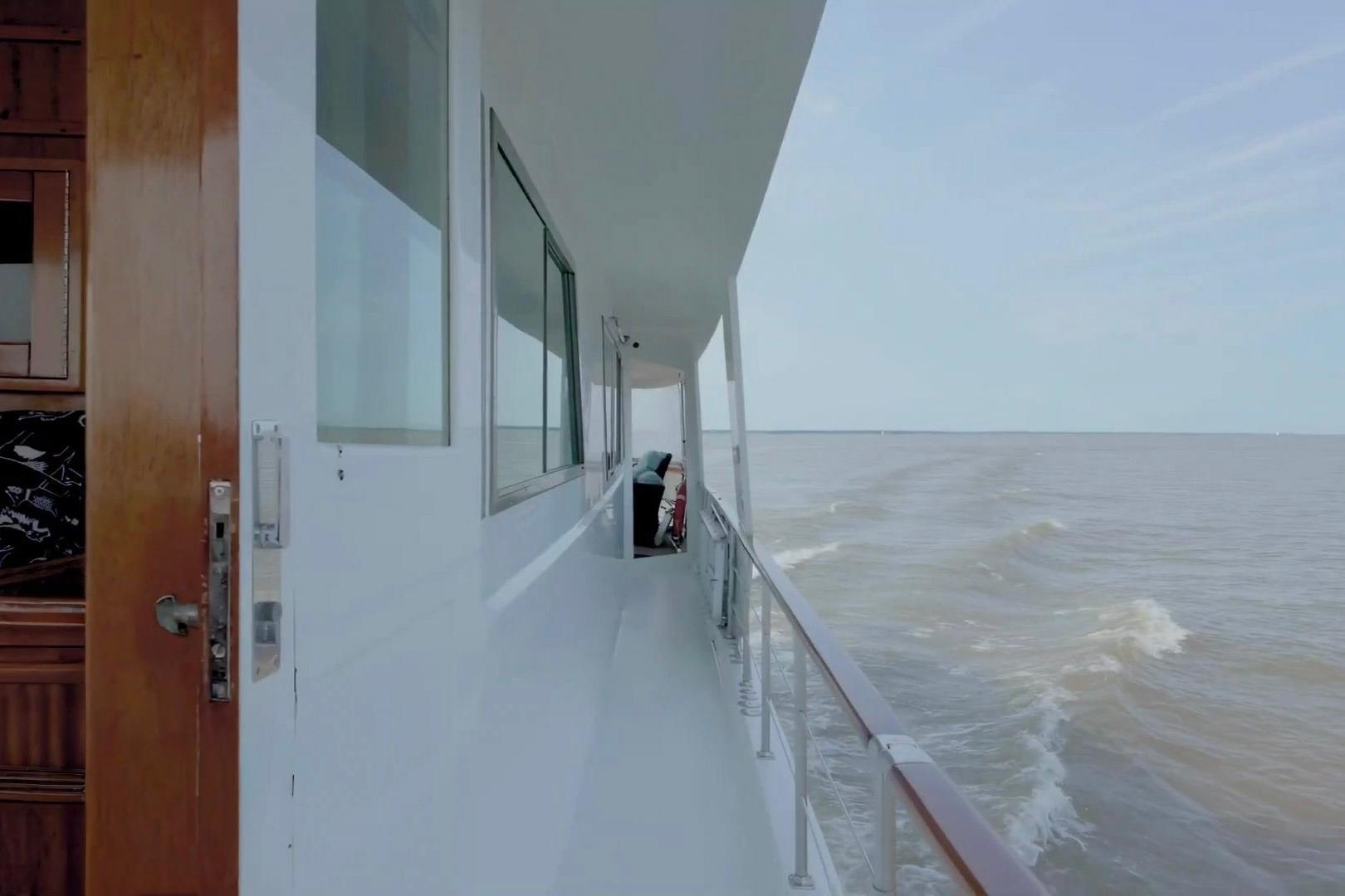 Side view of 1980 Hatteras 70 Motor Yacht cruising on open water.