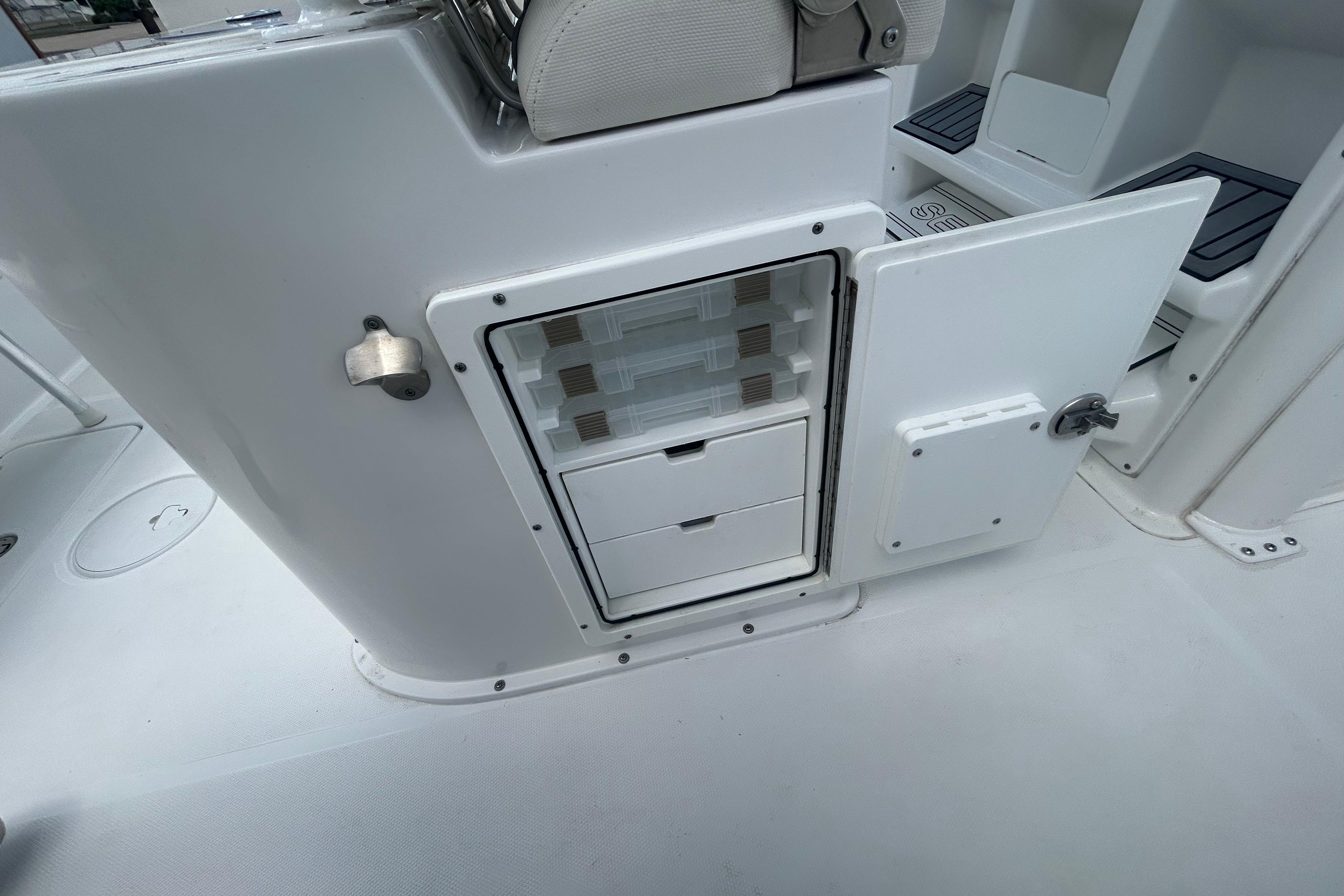 2023 Sea Hunt Gamefish 27 Coffin Box interior storage compartment with open door.