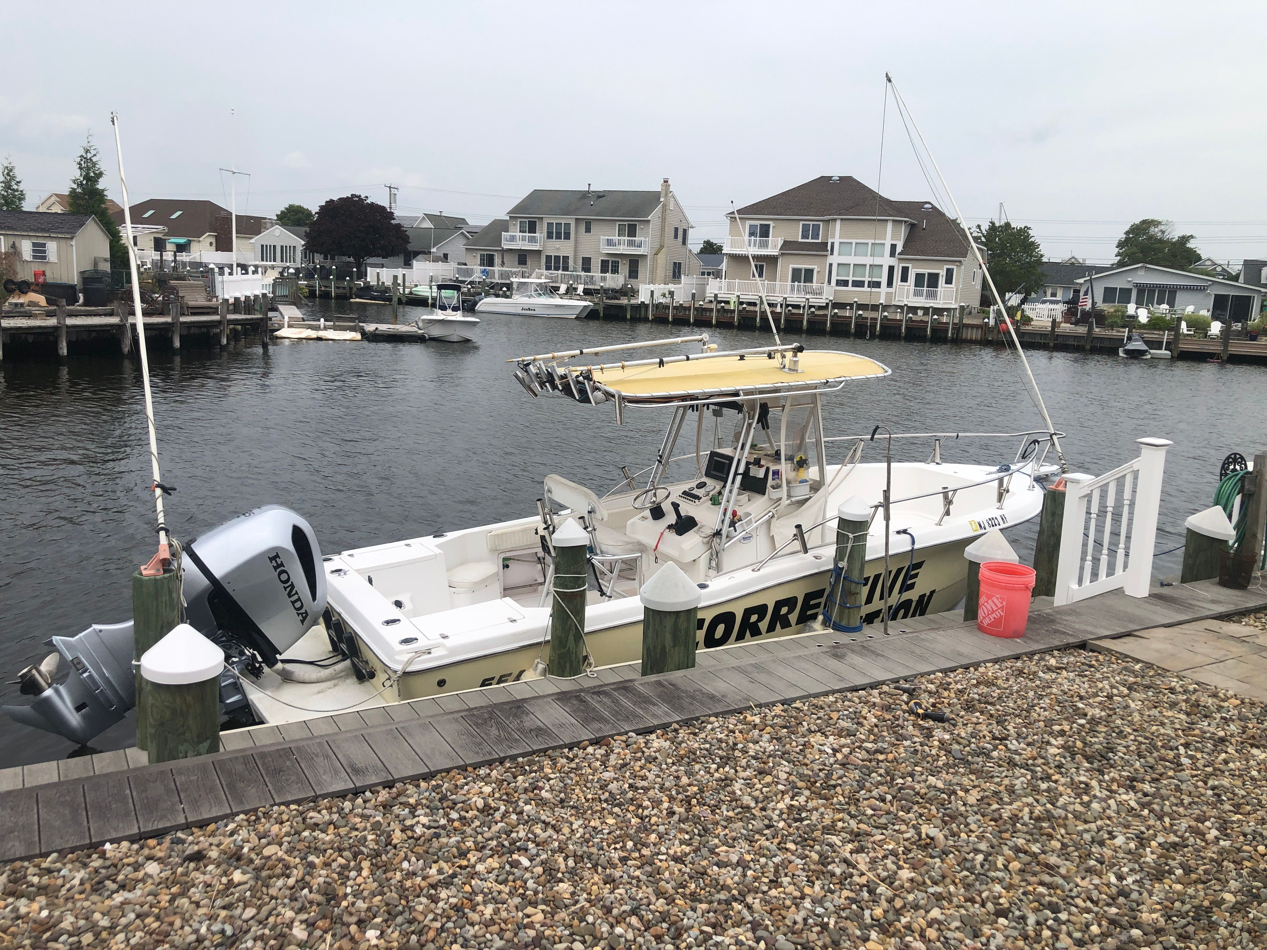 2003 Sea Pro 235 Center Console boat docked by waterfront.