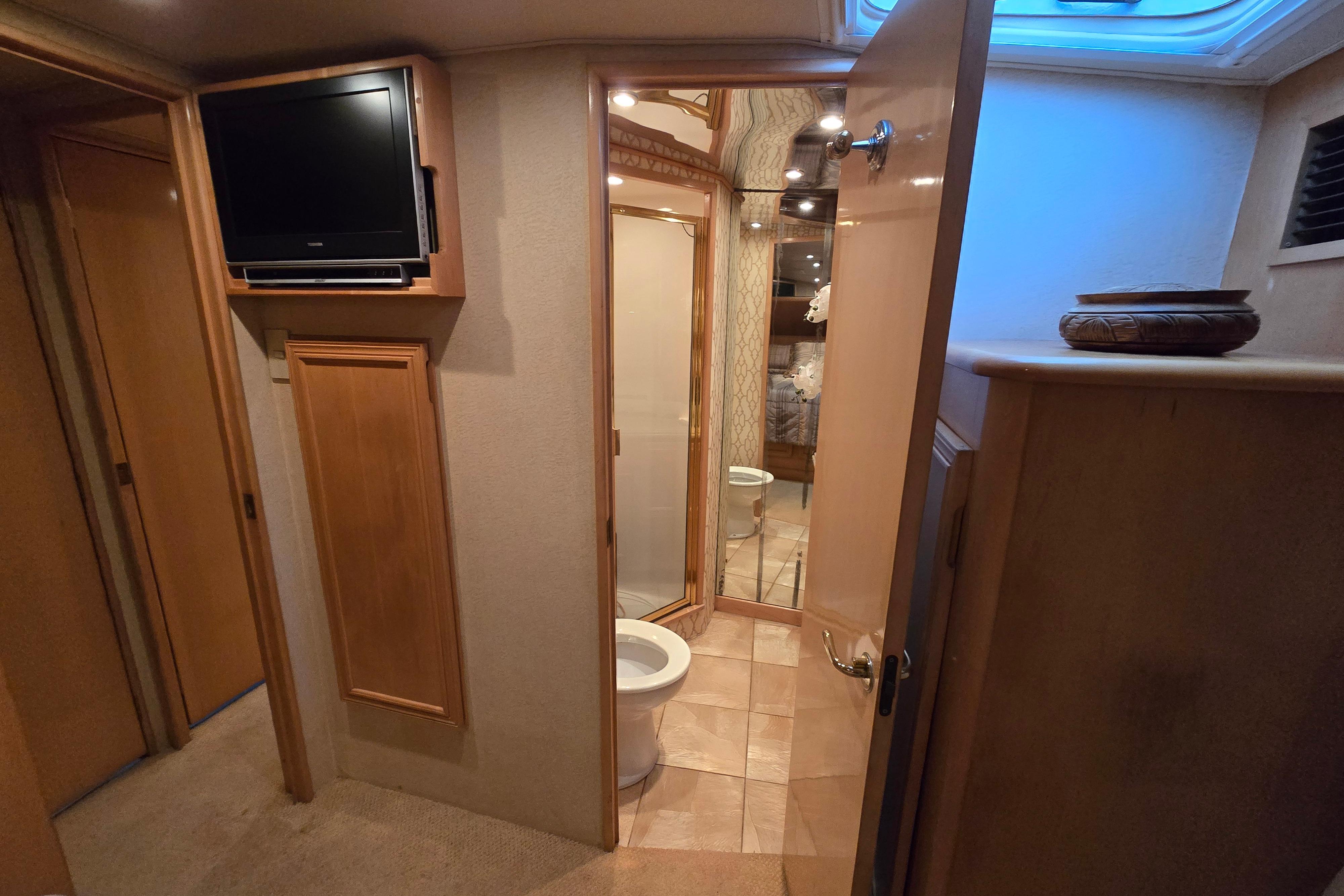 Interior of 2001 Cavileer 53 Convertible yacht showing bathroom and TV.