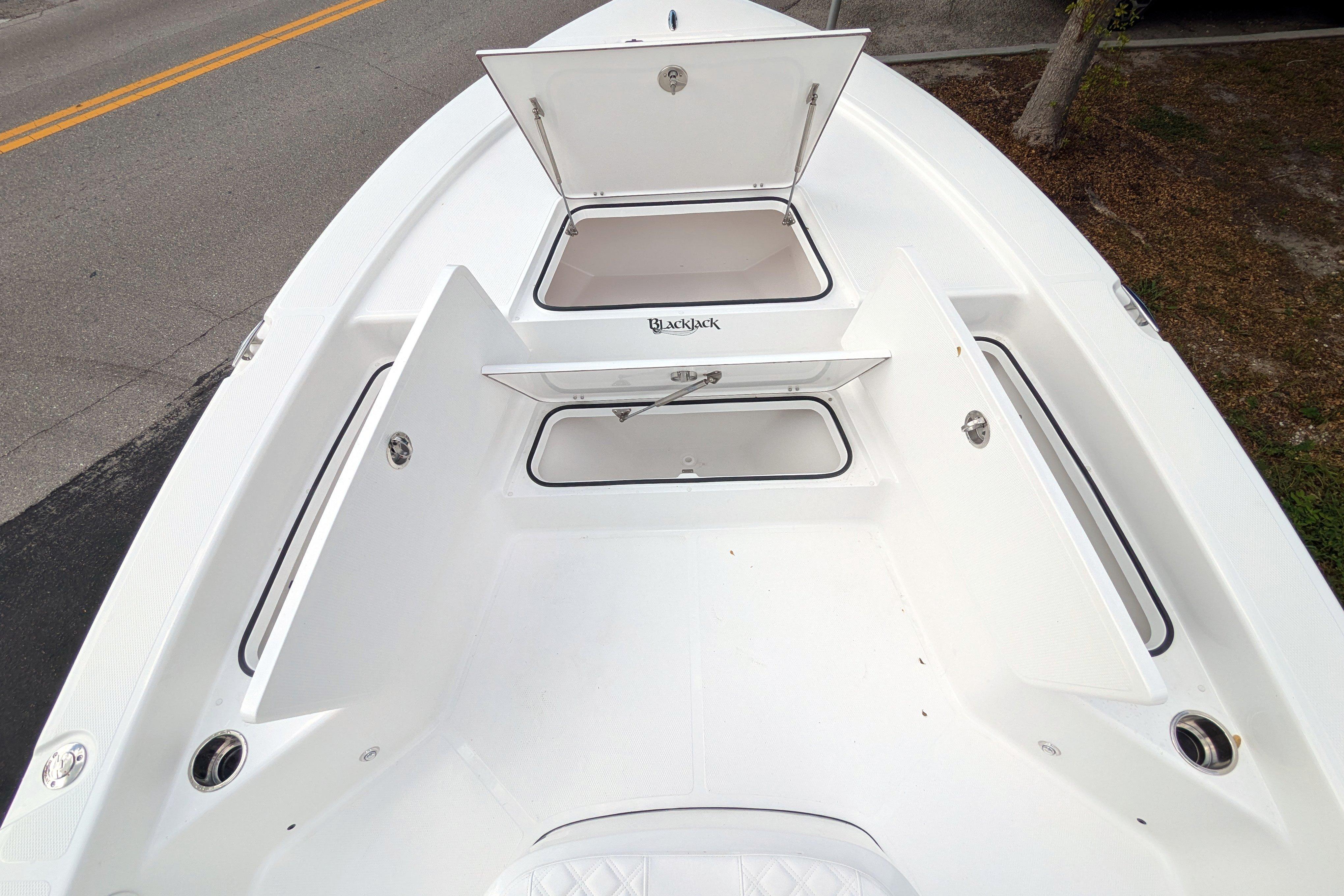 Open storage compartments on 2026 BlackJack 224 boat deck, showcasing spacious design.