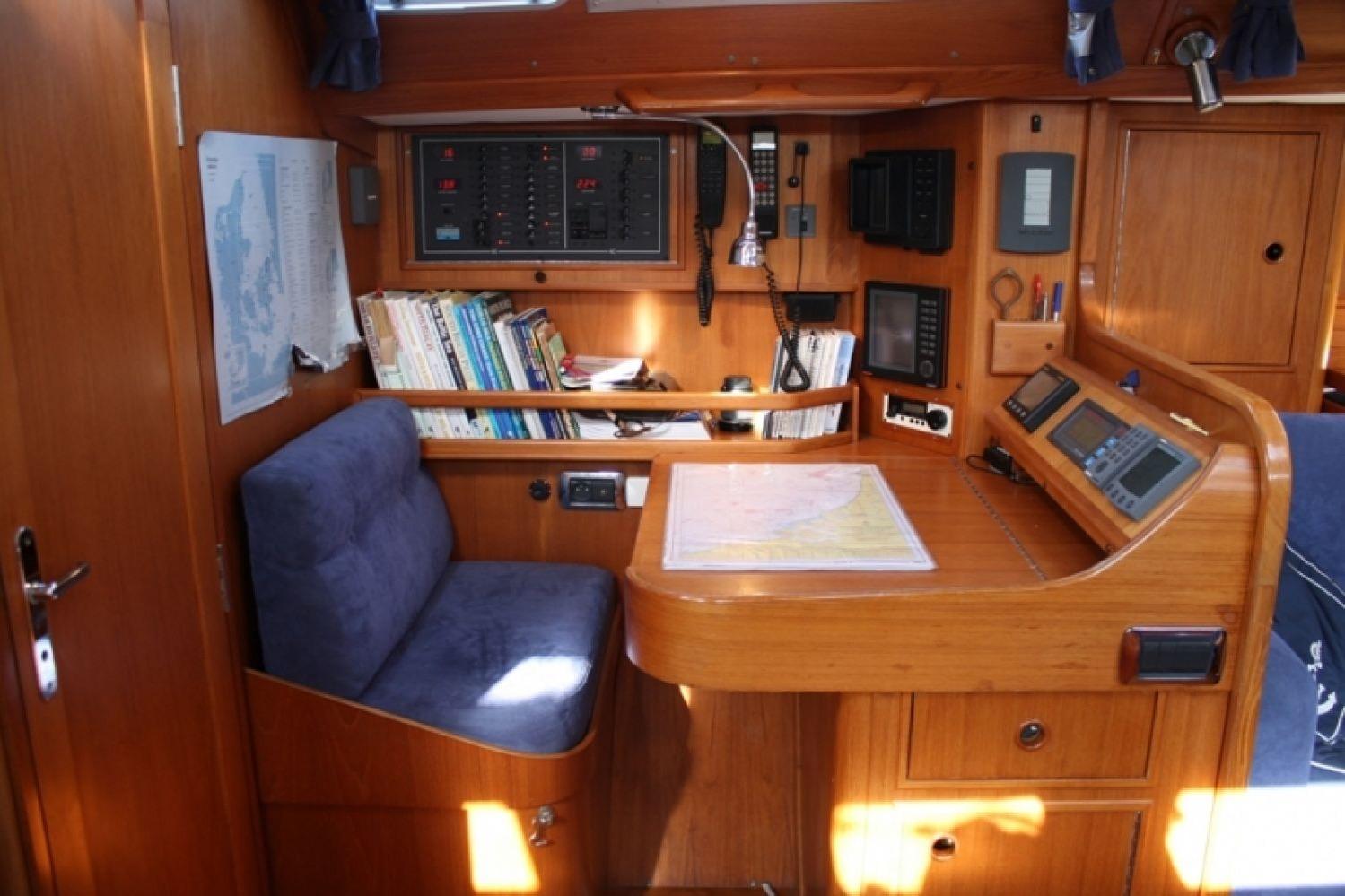 Navigation station inside 1996 Wauquiez Centurion 41s yacht, featuring charts and instruments.