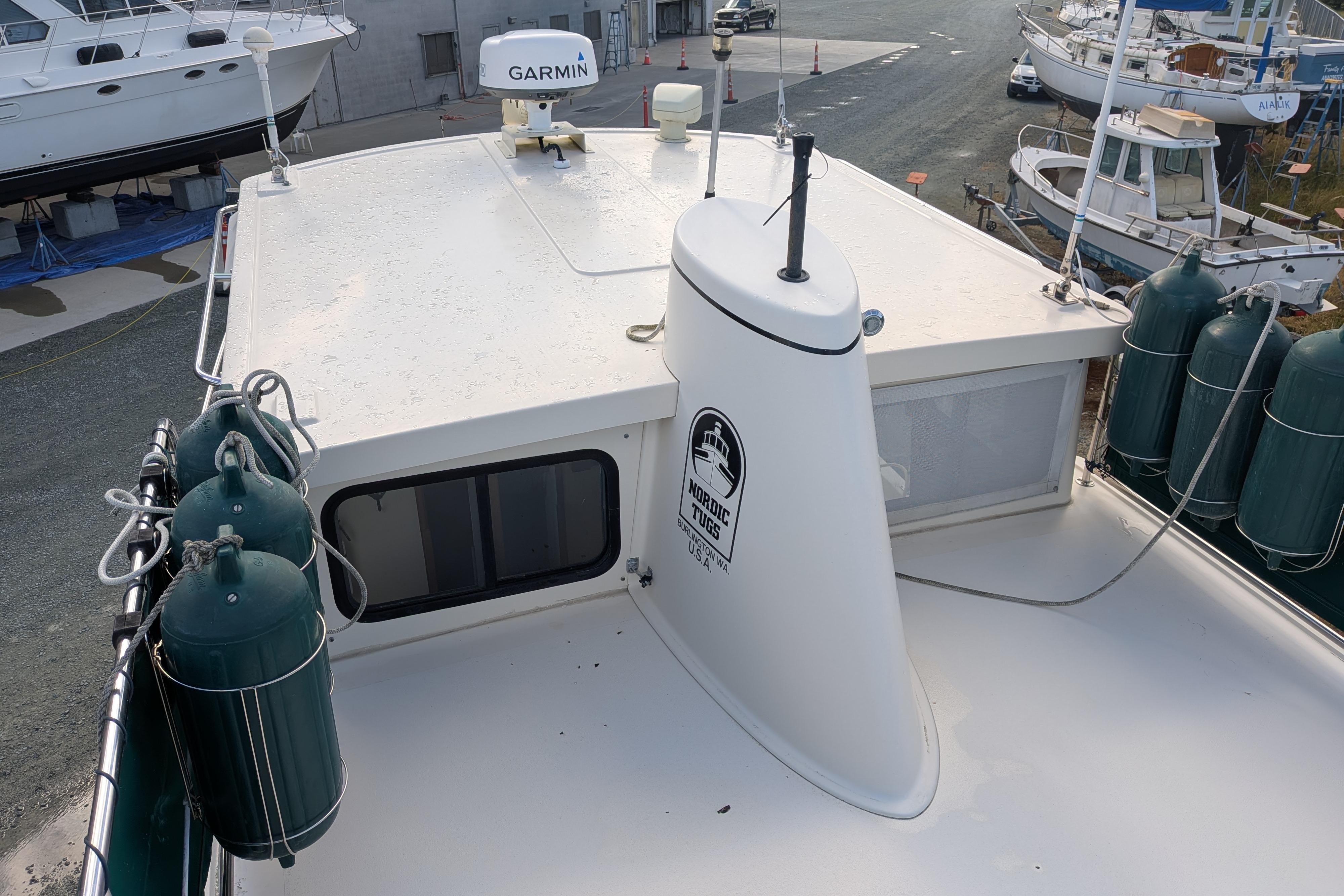 1998 Nordic Tug 32 boat deck with Garmin equipment and fenders in a marina.
