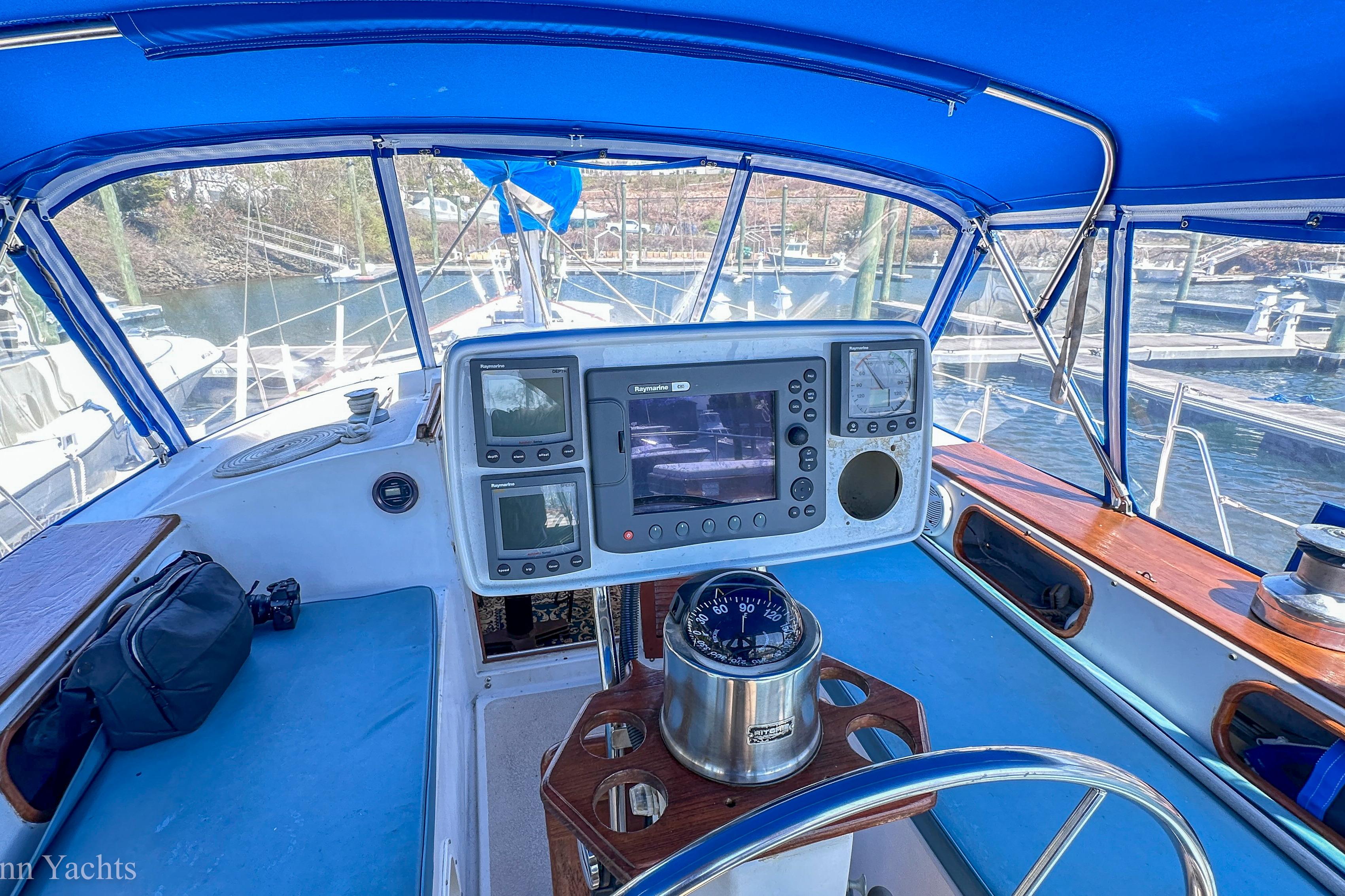 Cockpit of 1980 Irwin 46 sailboat with navigation equipment and blue canopy.