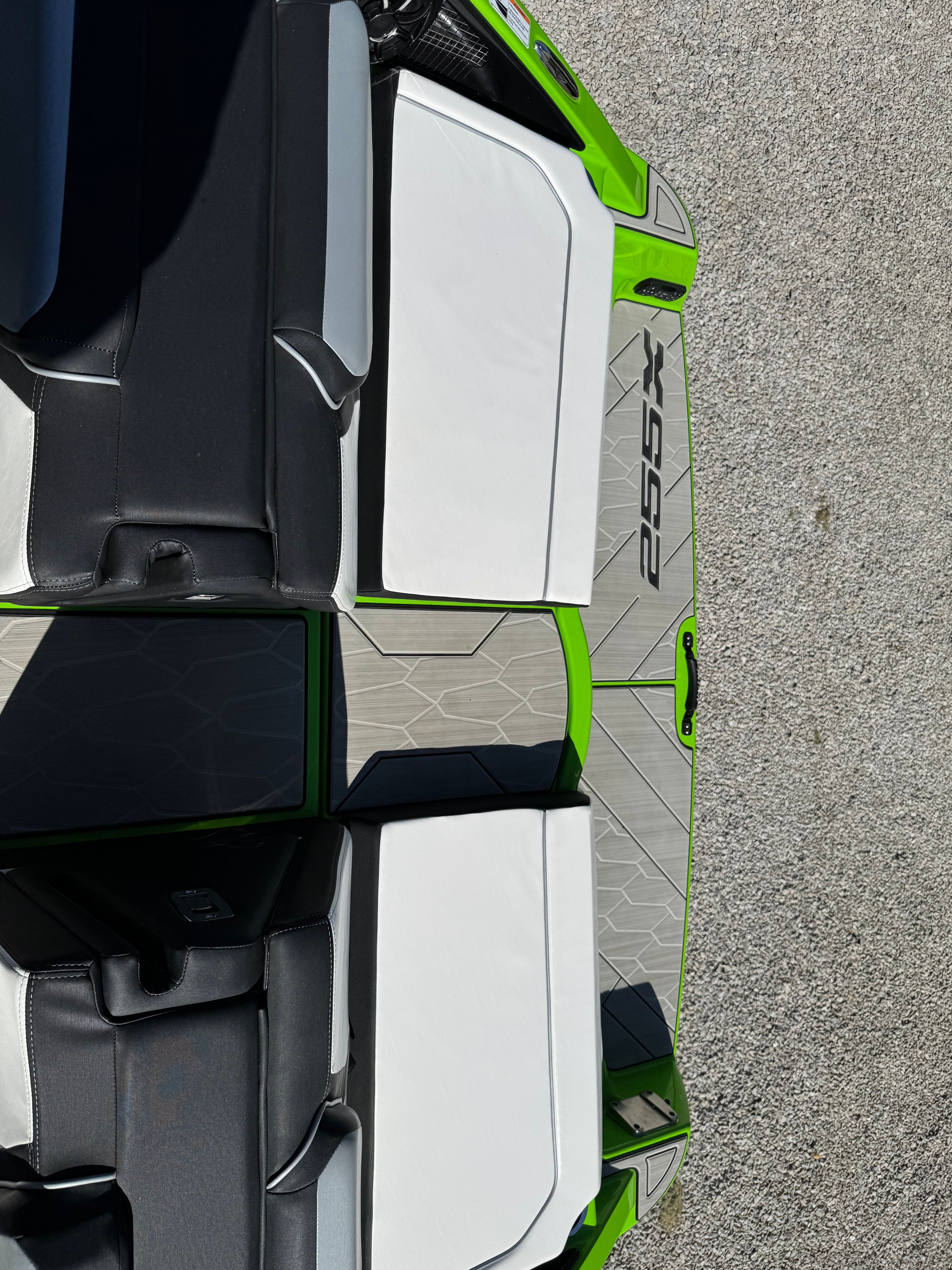 Yamaha Boats 255XD 2022: Modern seating with green accents and gray flooring.