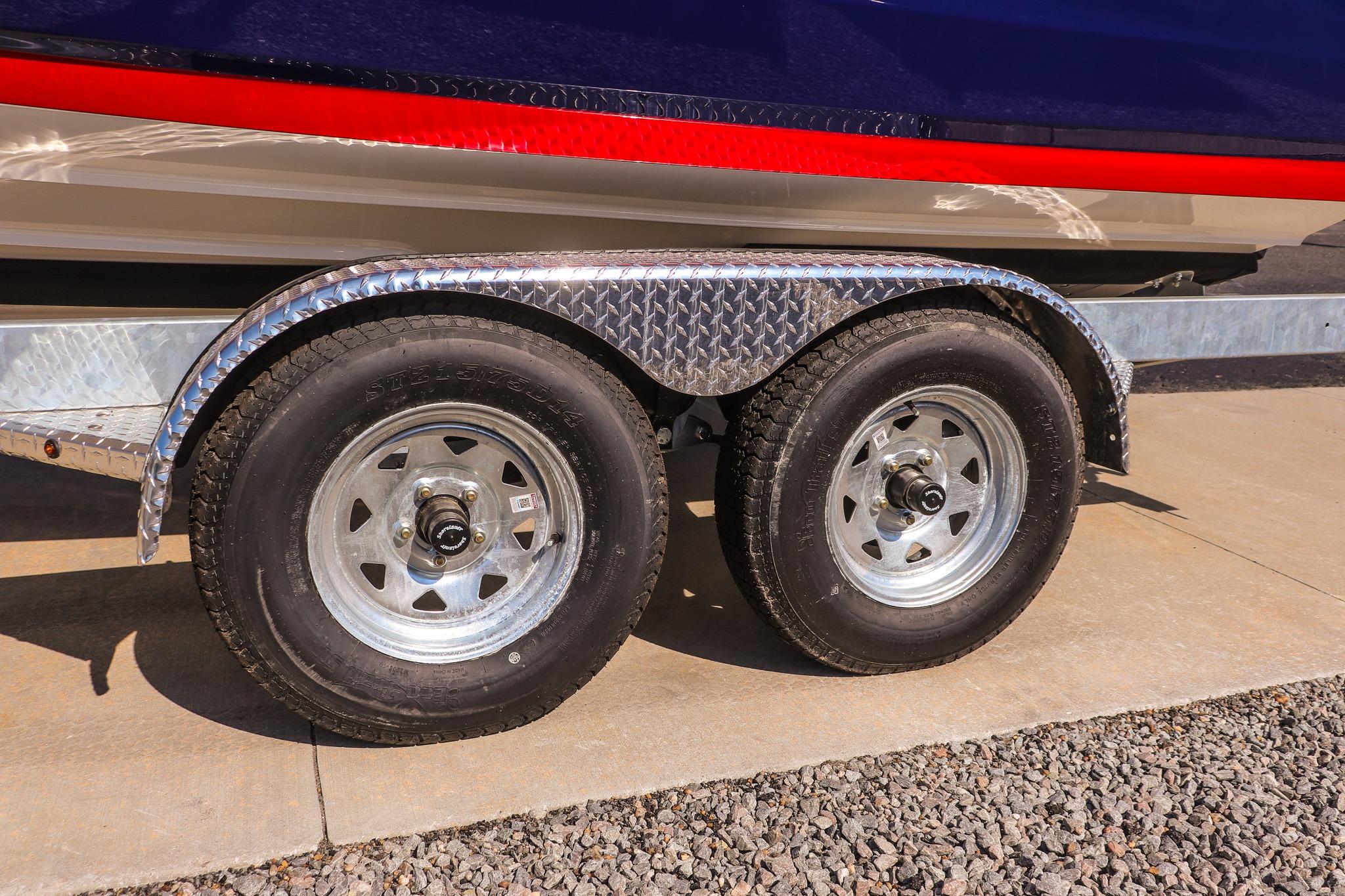 Trailer wheels of a 2026 Yamaha Boats 222SE on a concrete surface.