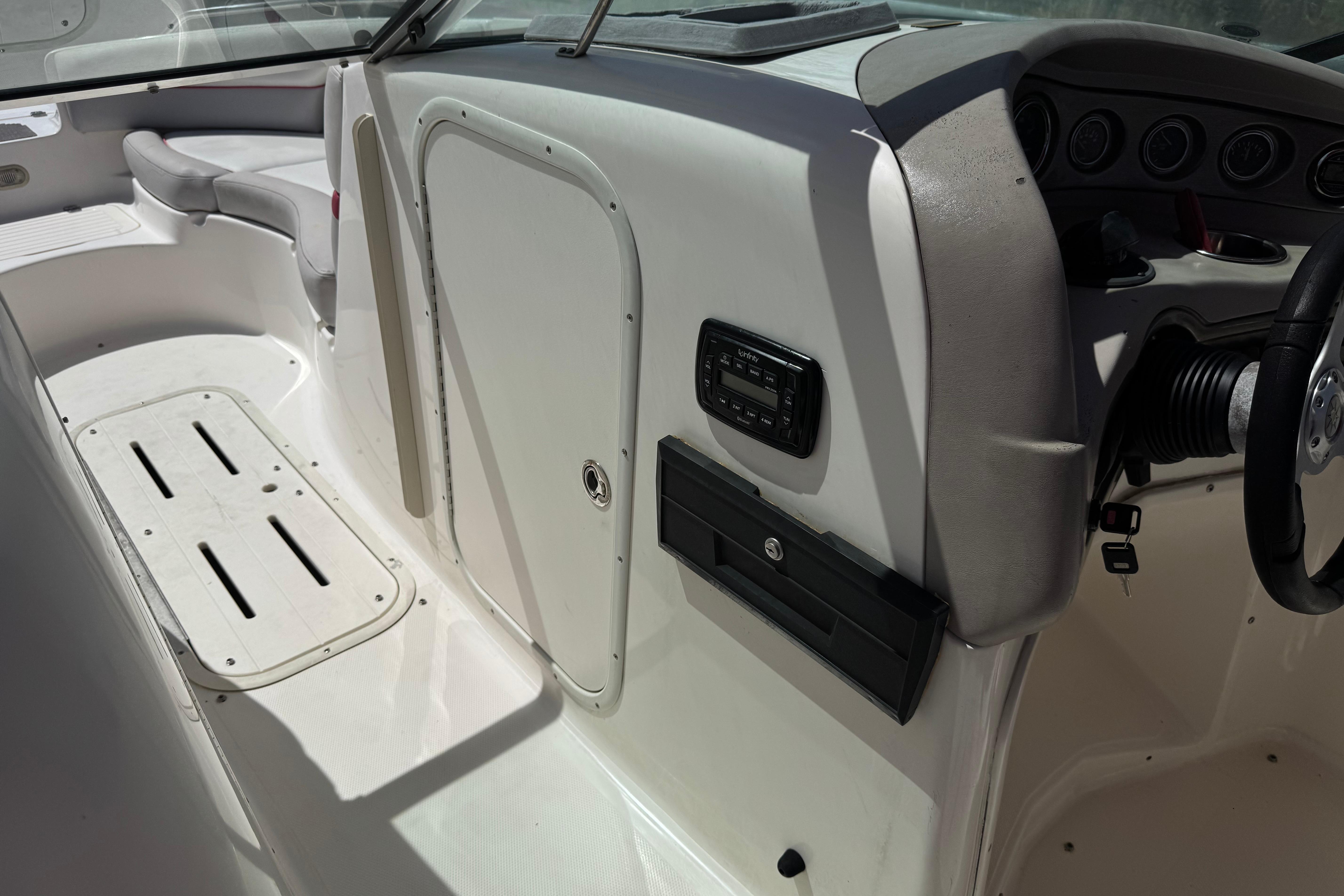 Interior of a 2010 Bryant 255 boat, featuring seating and control panel.