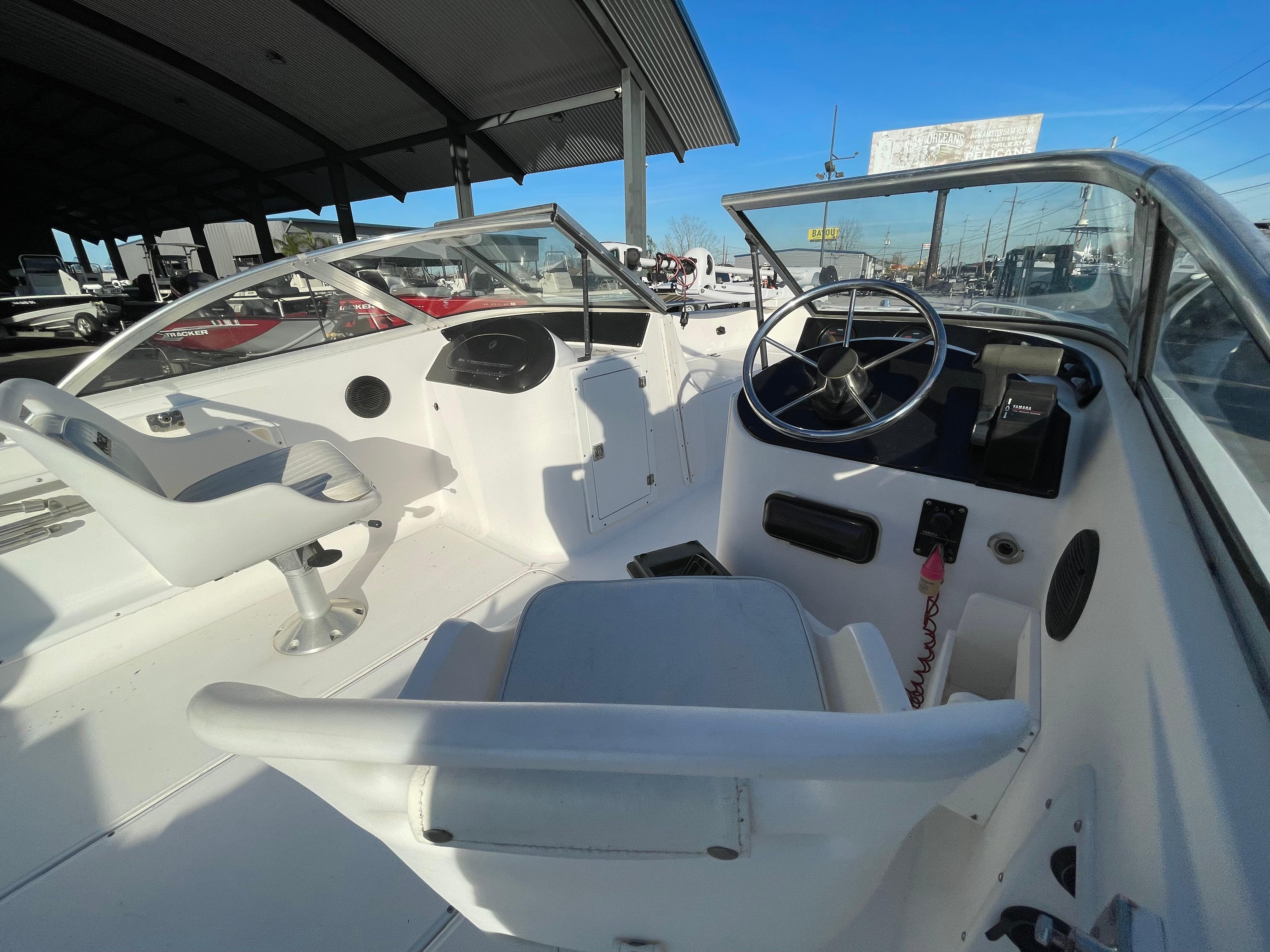 2002 Angler 18 DC boat interior with steering wheel and seating under a canopy.