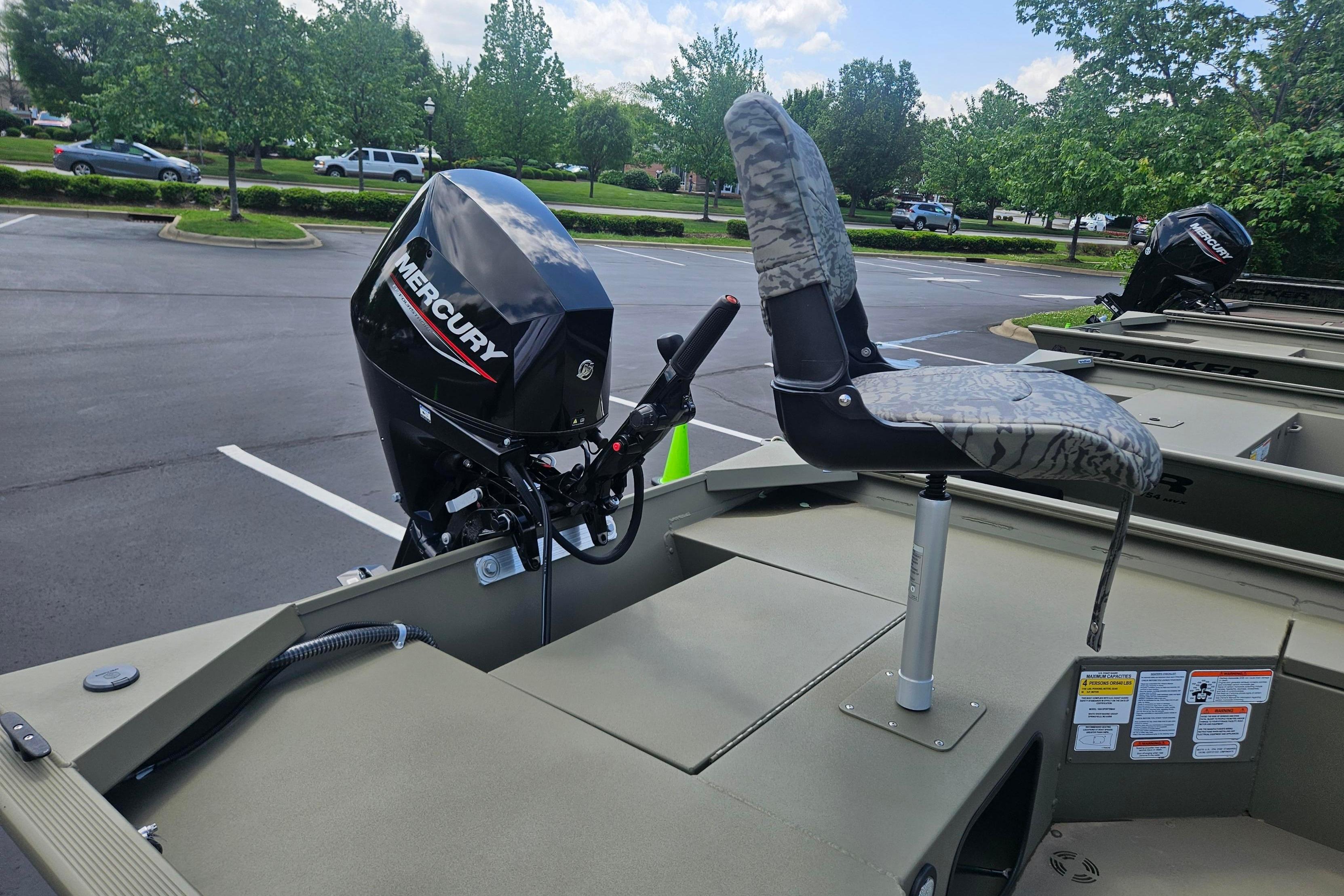 2026 Tracker Grizzly 1654 T Sportsman boat with Mercury outboard motor in parking lot.