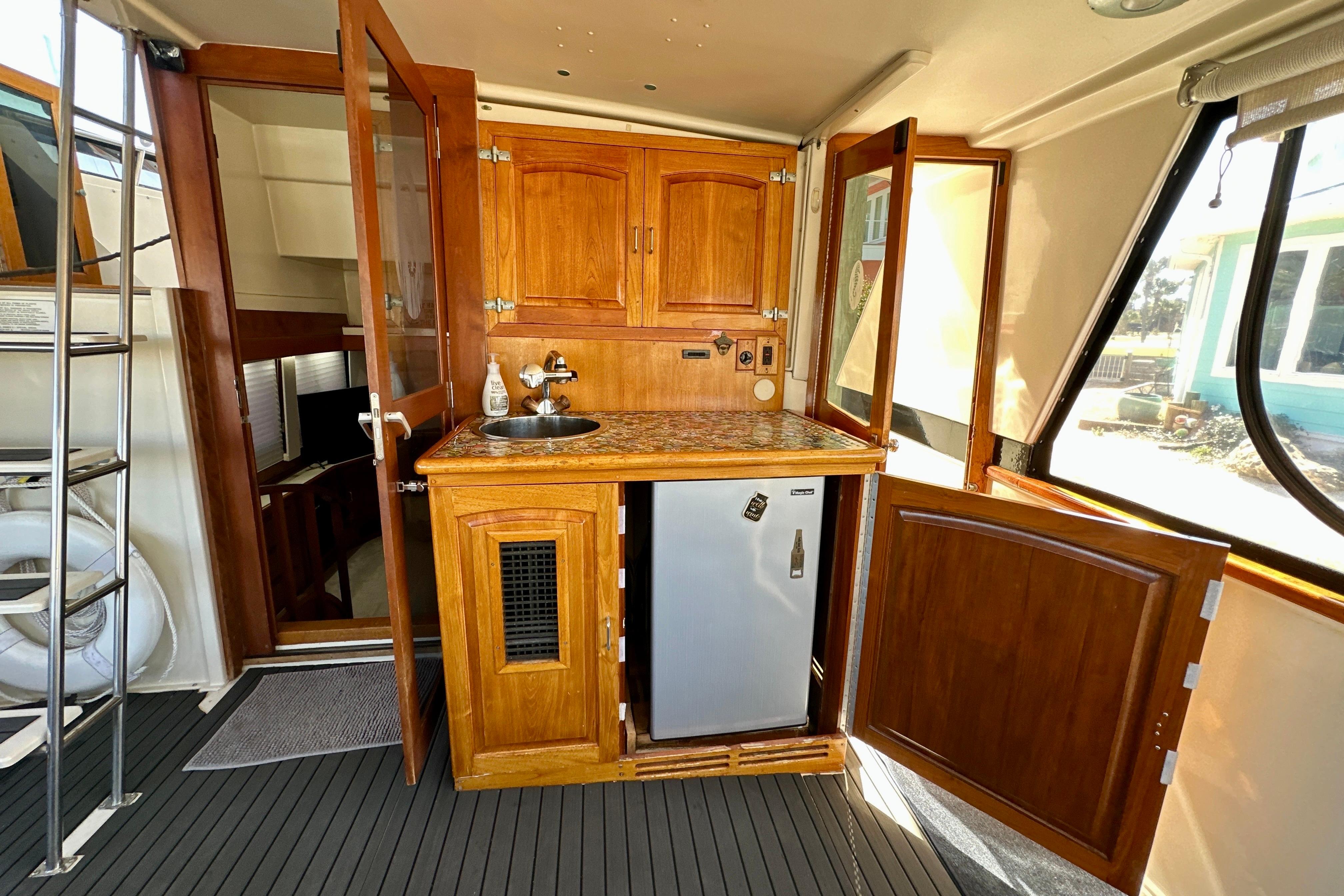 1988 Californian 45 Motor Yacht interior with wooden cabinetry and compact kitchenette.
