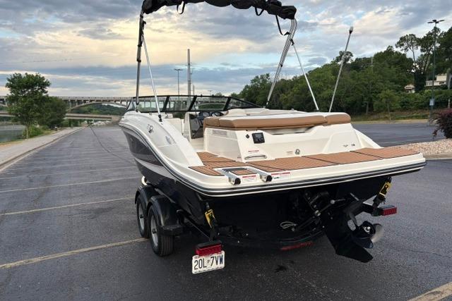 2017 Searay SPX210 boat parked on a riverside lot, featuring sleek design and dual axles.