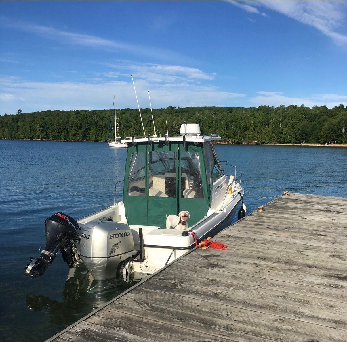 A 1999 Seaswirl Striper 2100 docked at a wooden pier, surrounded by calm water.
