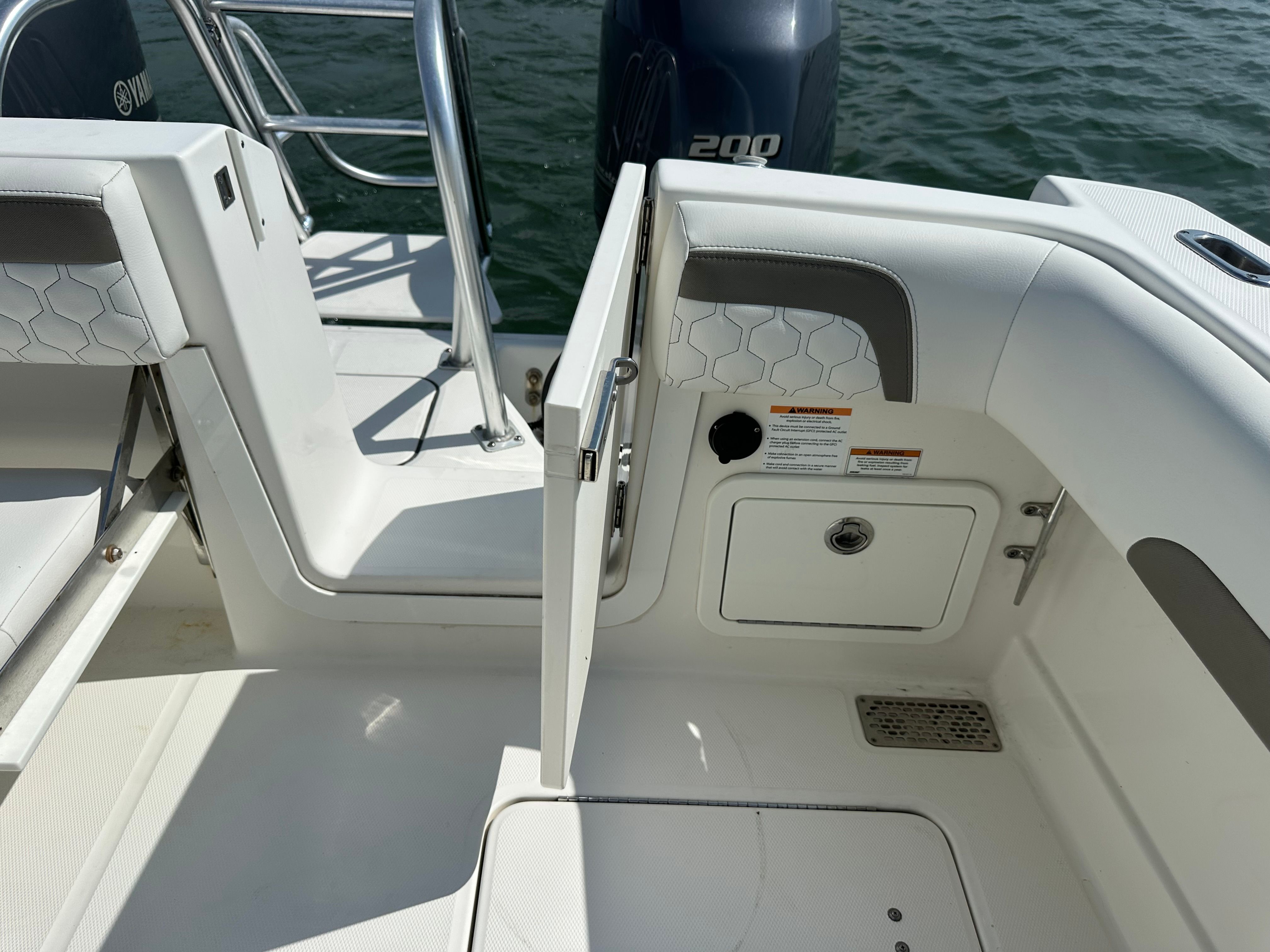 The image shows the stern of a boat with an open door and an engine in the background.