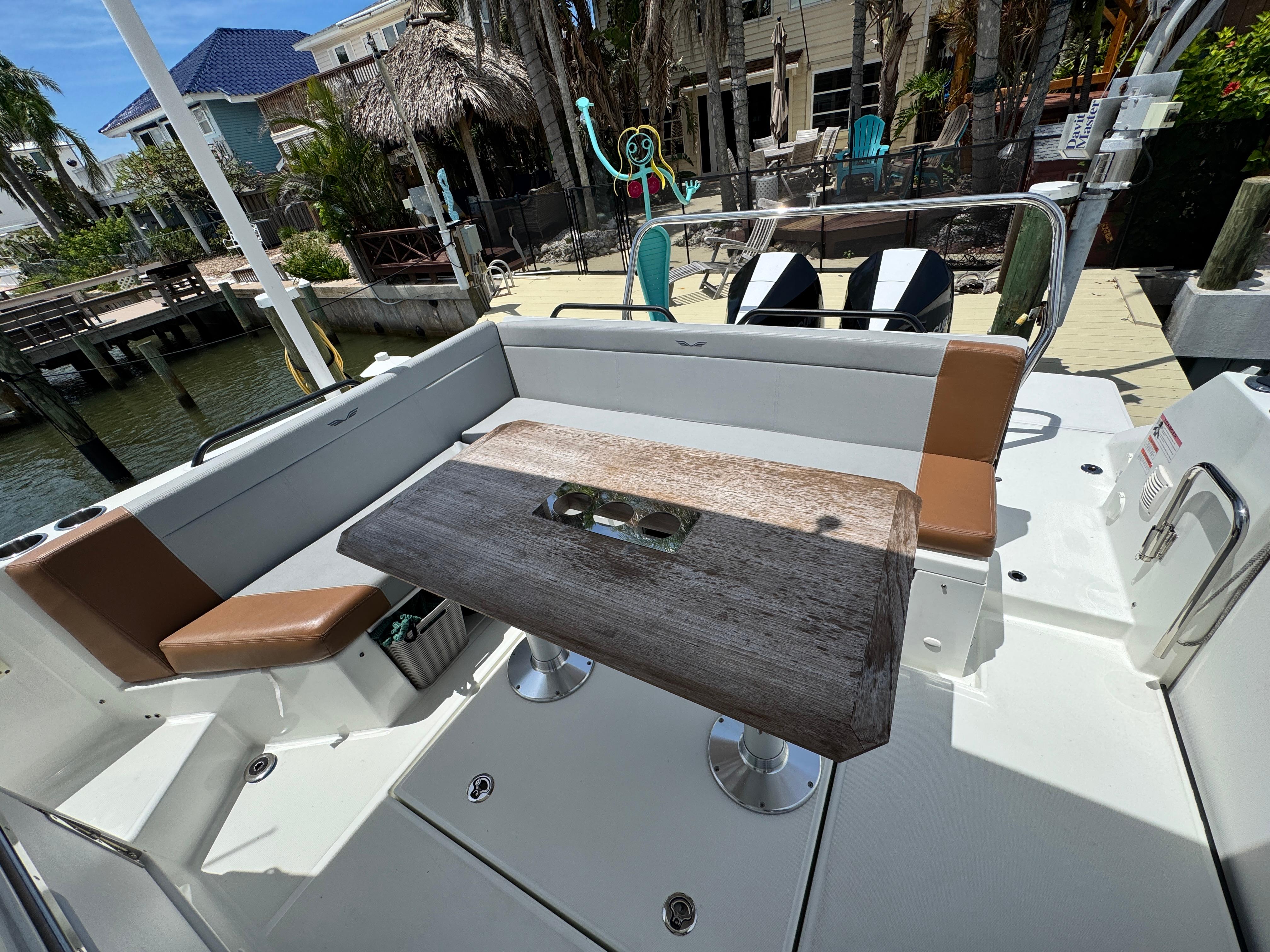 2022 Beneteau Flyer 9 SUNdeck boat interior with seating and table, docked near waterfront homes.