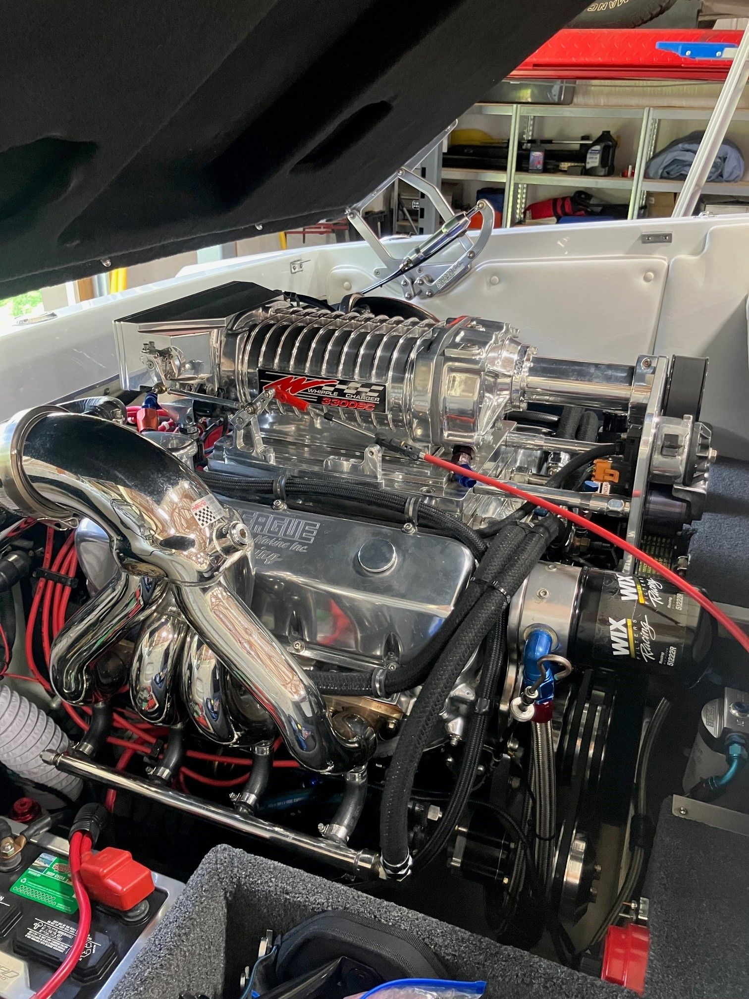 A shiny engine with chrome parts inside a boat.