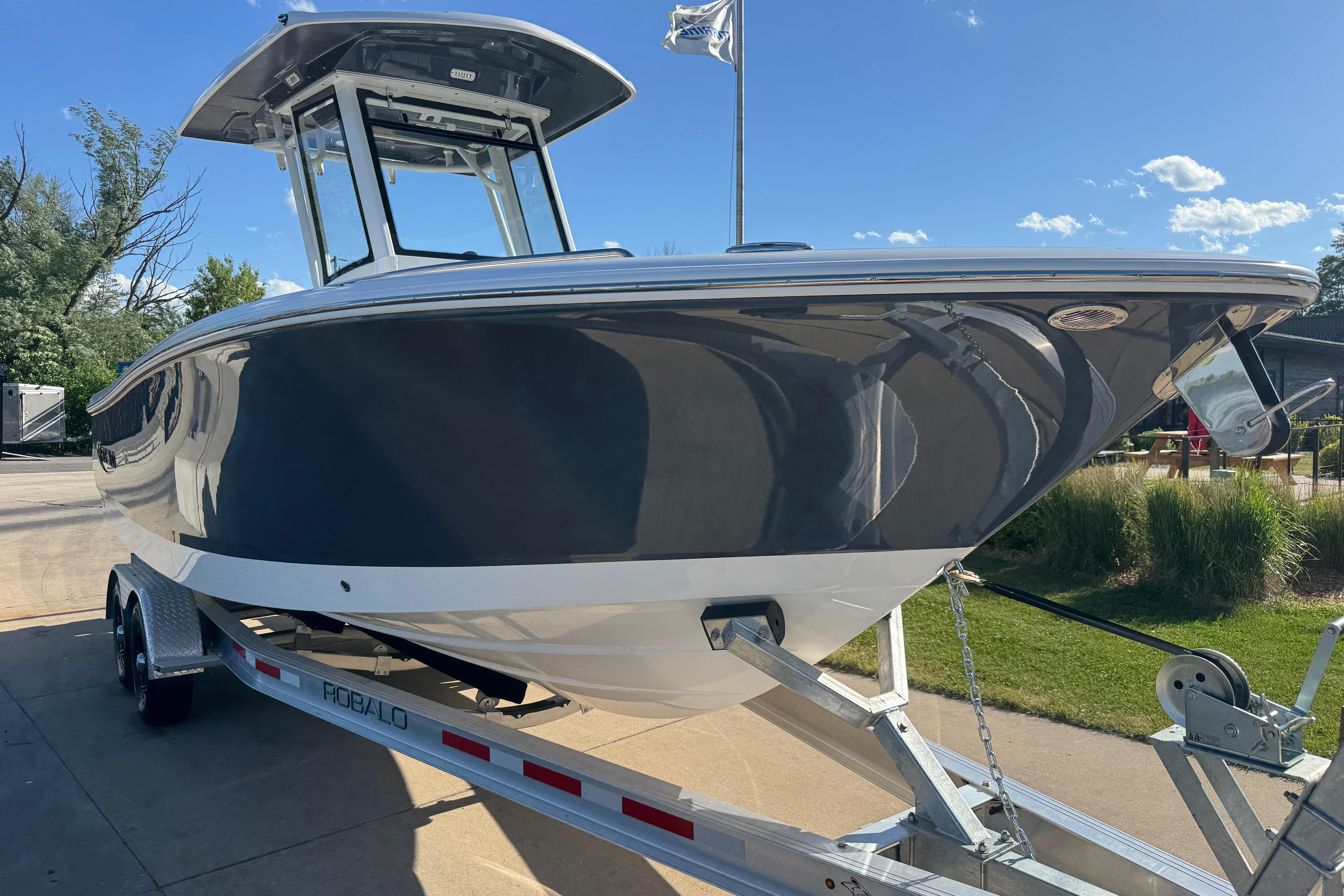 2026 Robalo R250 Center Console boat on trailer, sunny day, outdoor setting.