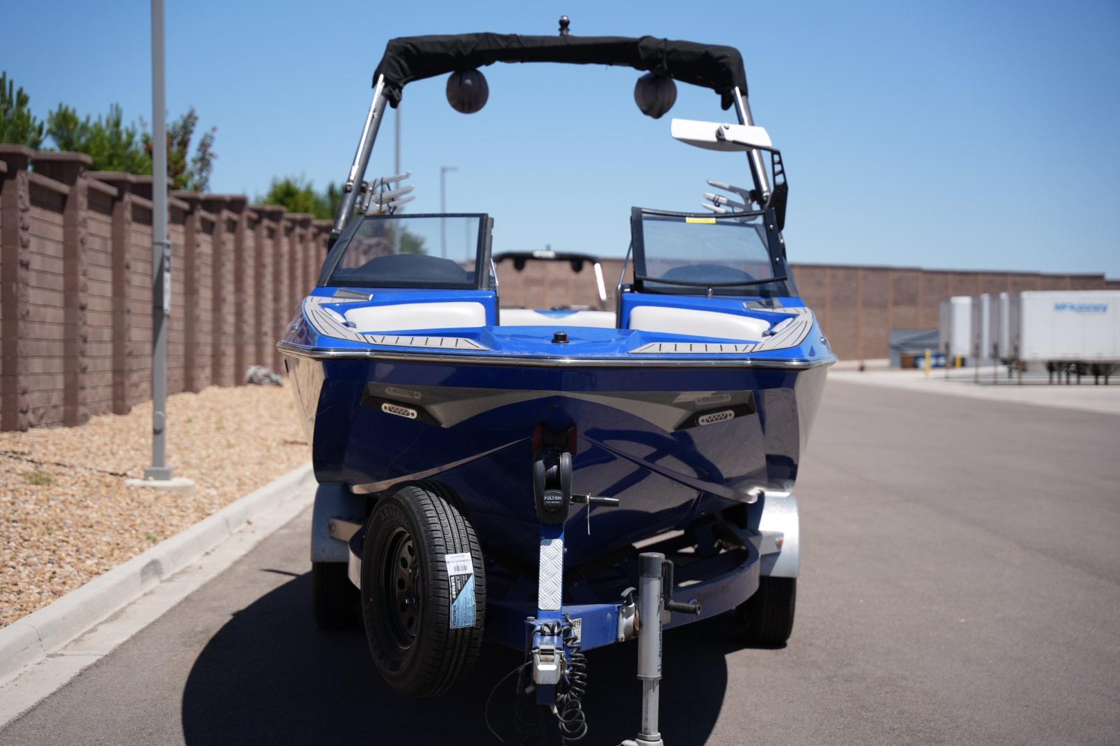 2015 Axis A24 boat on trailer, parked on a sunny street.