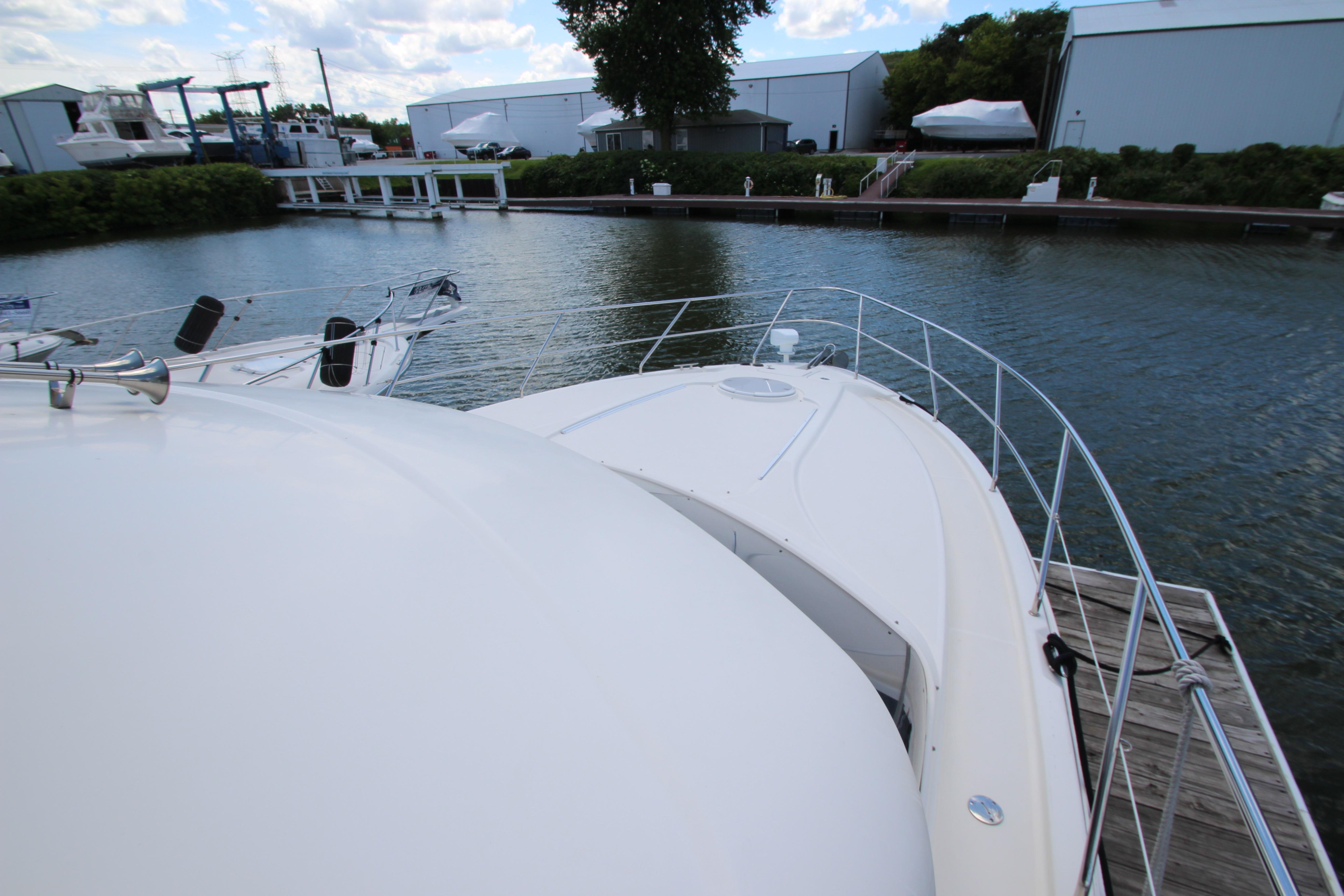 2006 Silverton 38 Sport Bridge yacht docked at a marina, surrounded by calm waters.