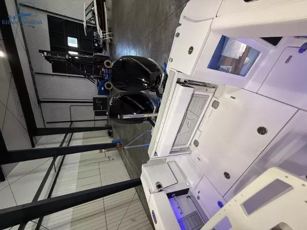 2025 Blackfin 272CC boat in a modern indoor marina setting.