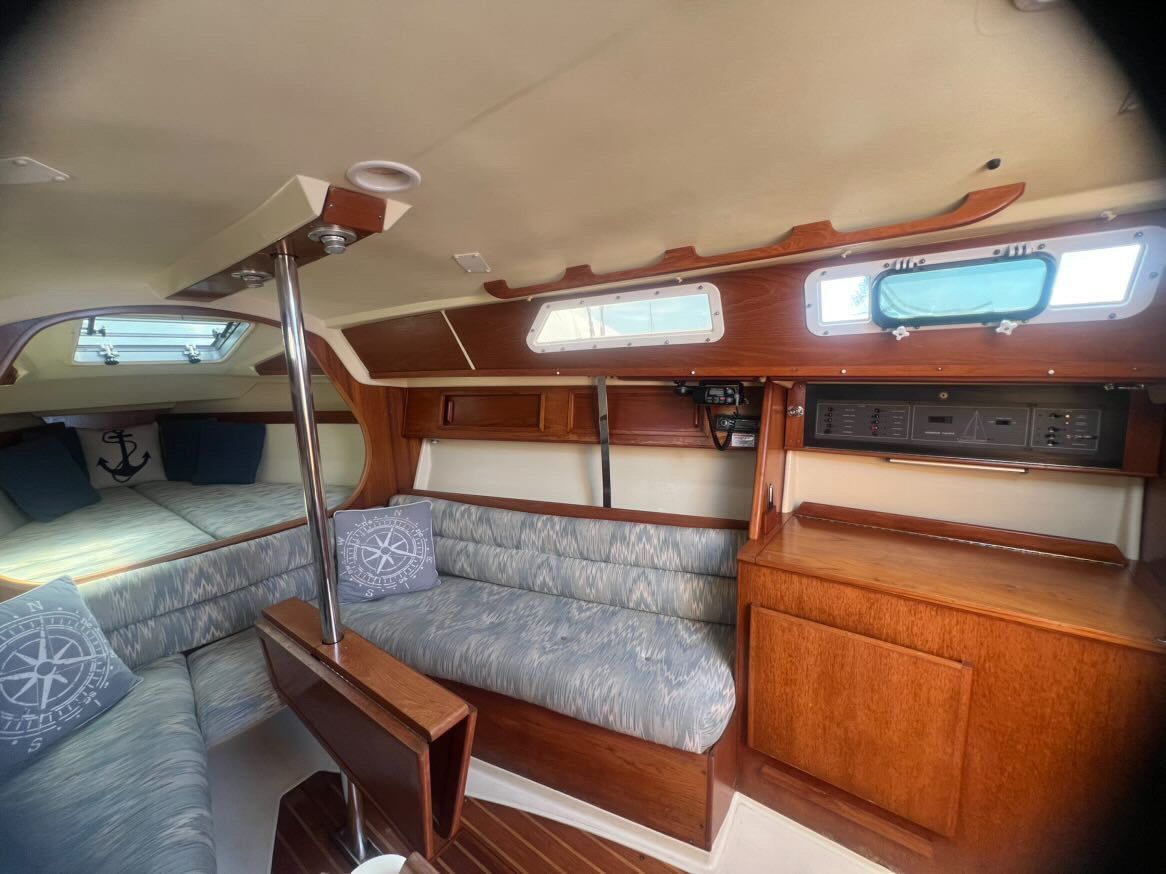 Interior of a 1988 Pearson 28 sailboat with cozy seating and wood finishes.