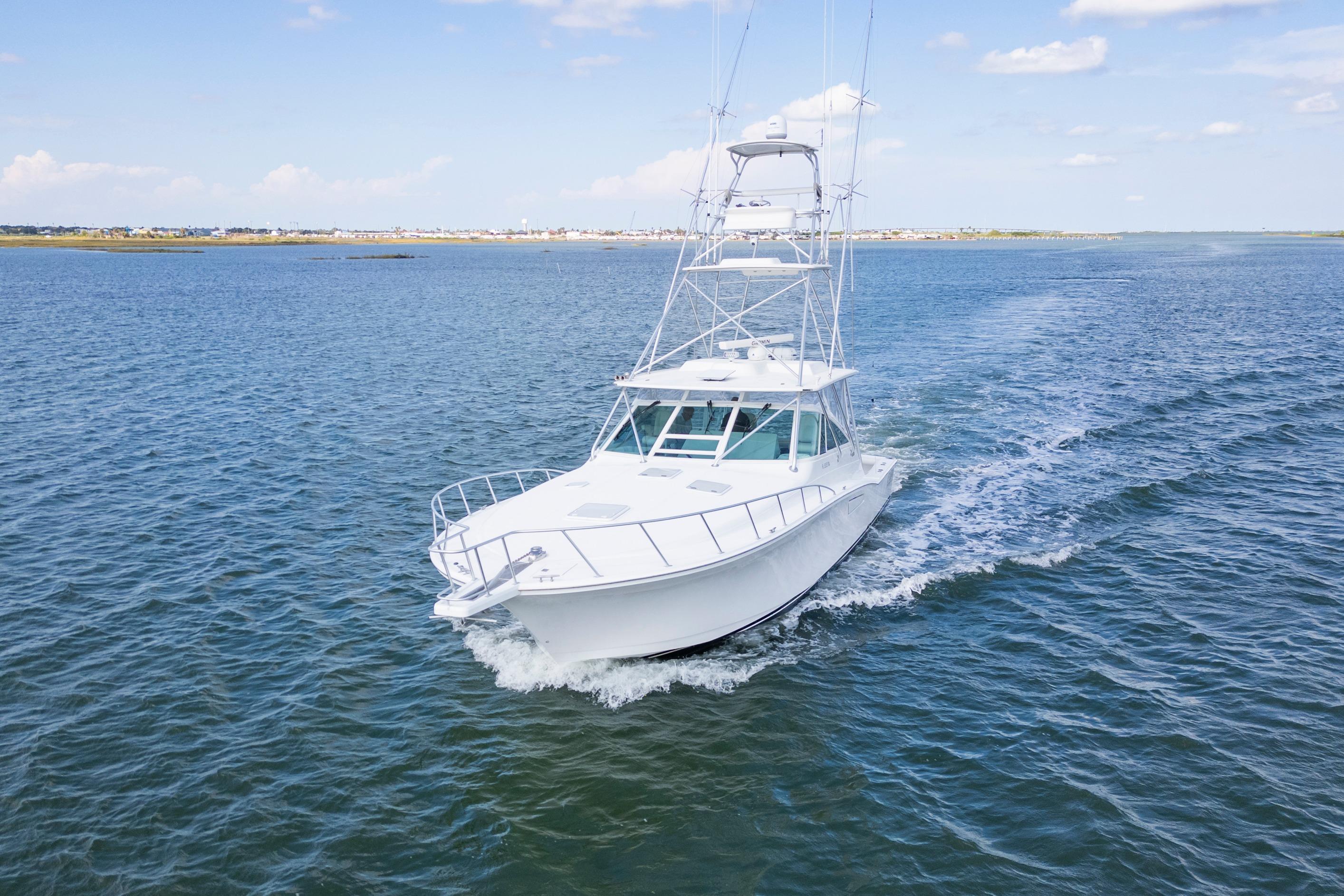 2010 Cabo 45 Express yacht cruising on open water under a clear sky.