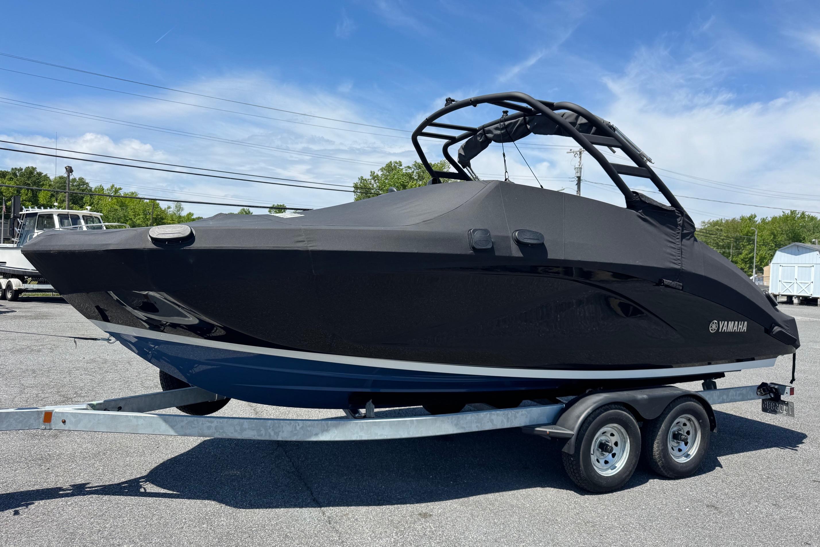 2023 Yamaha Boats 222SD covered on trailer, parked outdoors under blue sky.