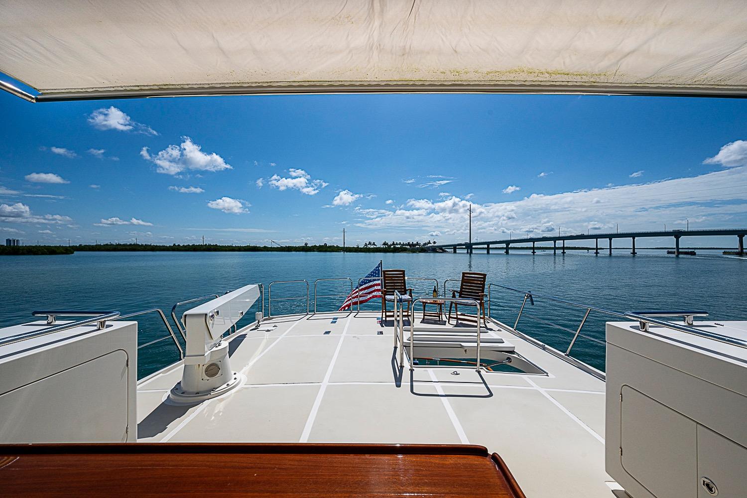 Luxurious 2014 Marlow 80 Explorer yacht deck with ocean view and bridge in background.