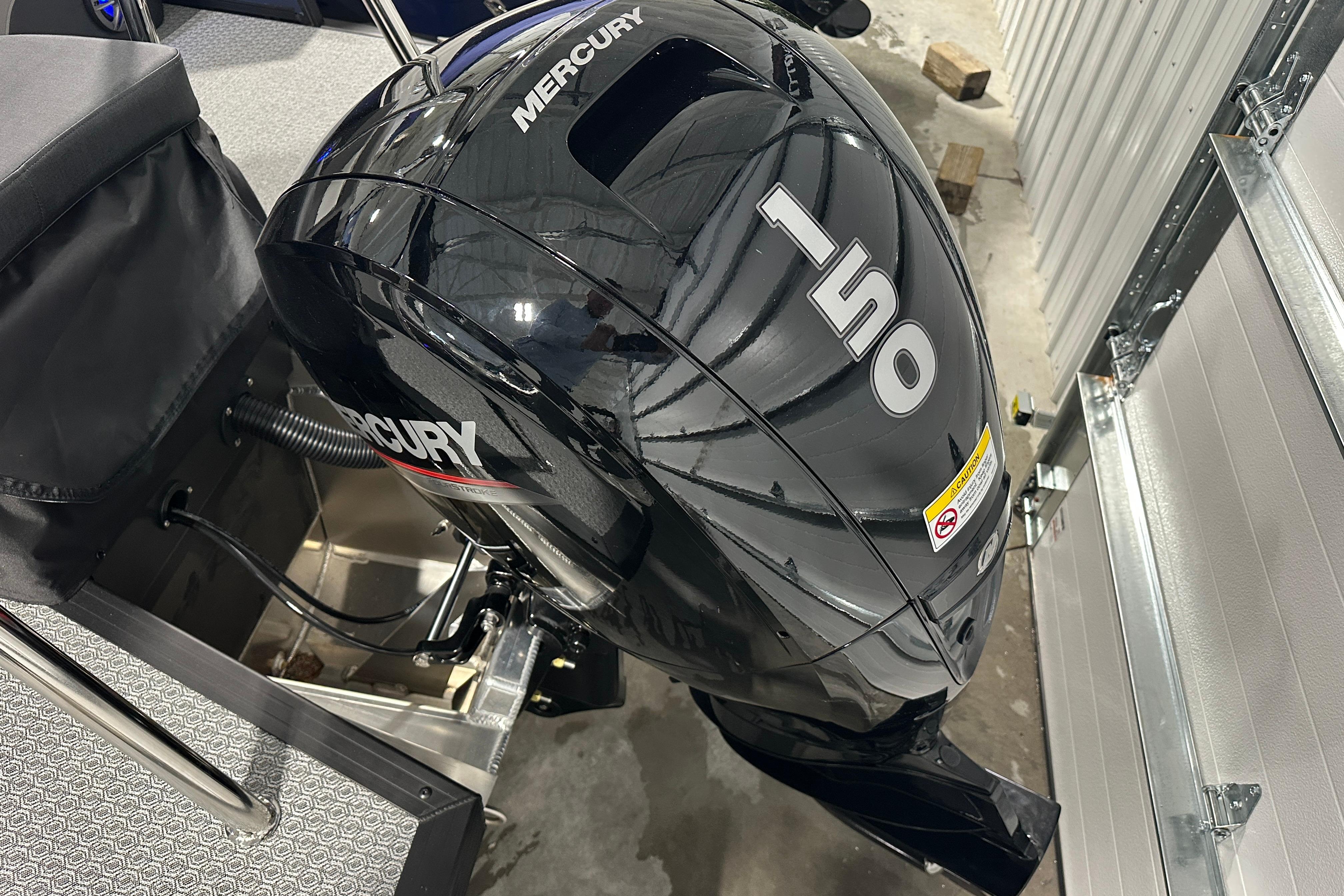 2026 Evotti 523QL boat with Mercury 150 outboard motor in a garage setting.