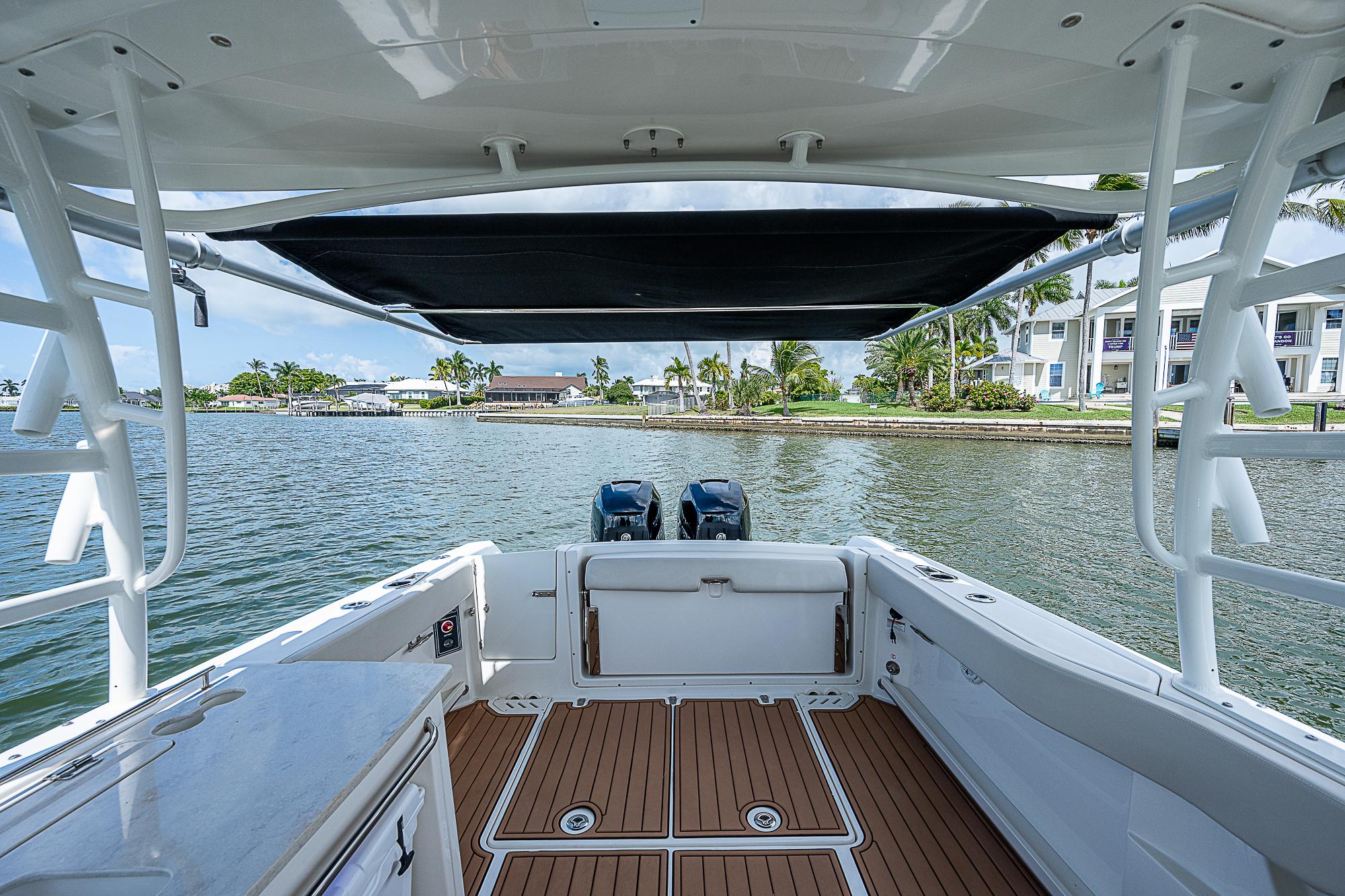 2018 Boston Whaler 270 Vantage boat with dual engines, docked by waterfront homes.