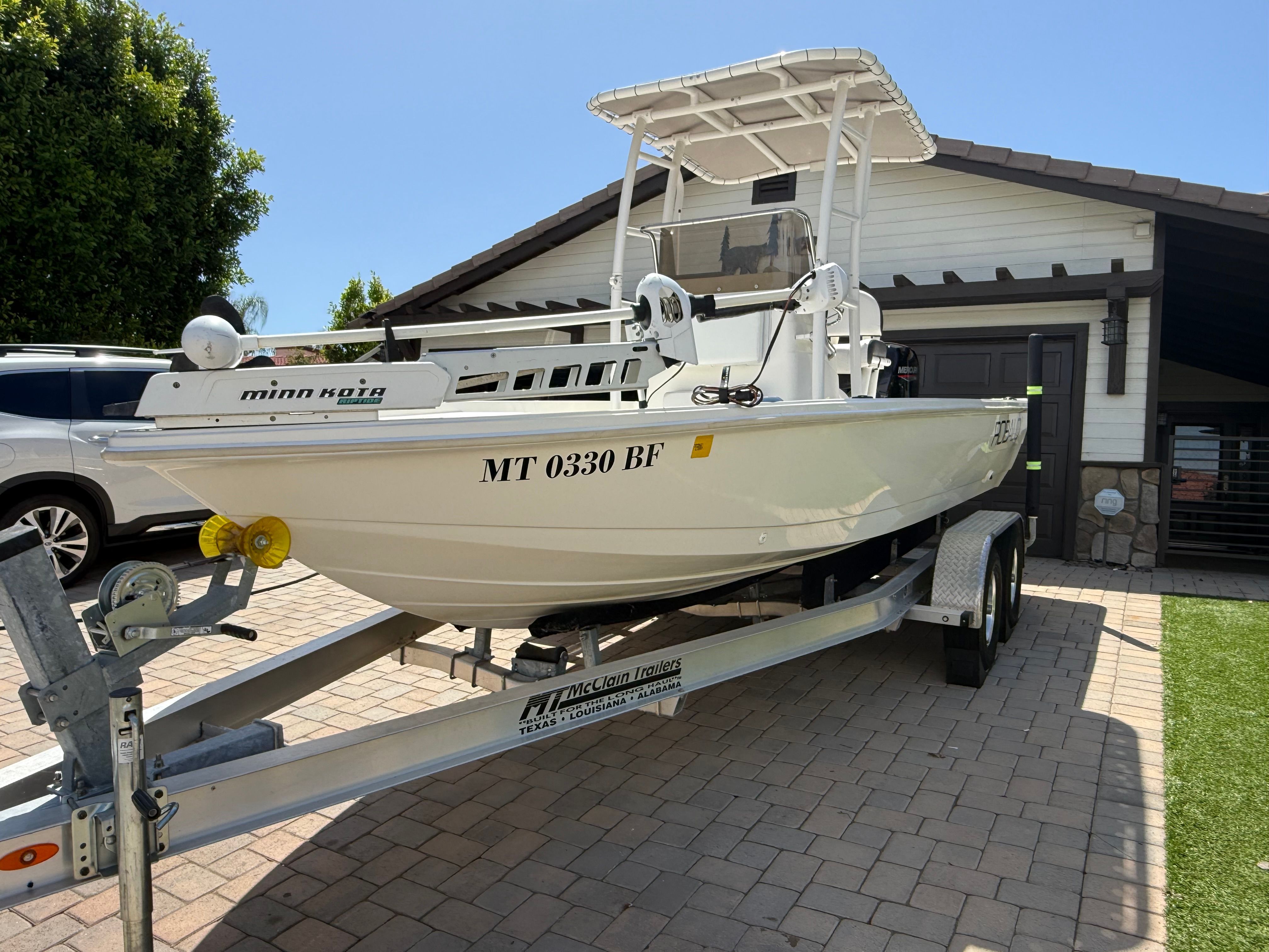 1998 Robalo 2100 Bay Hunter on trailer in front of house.