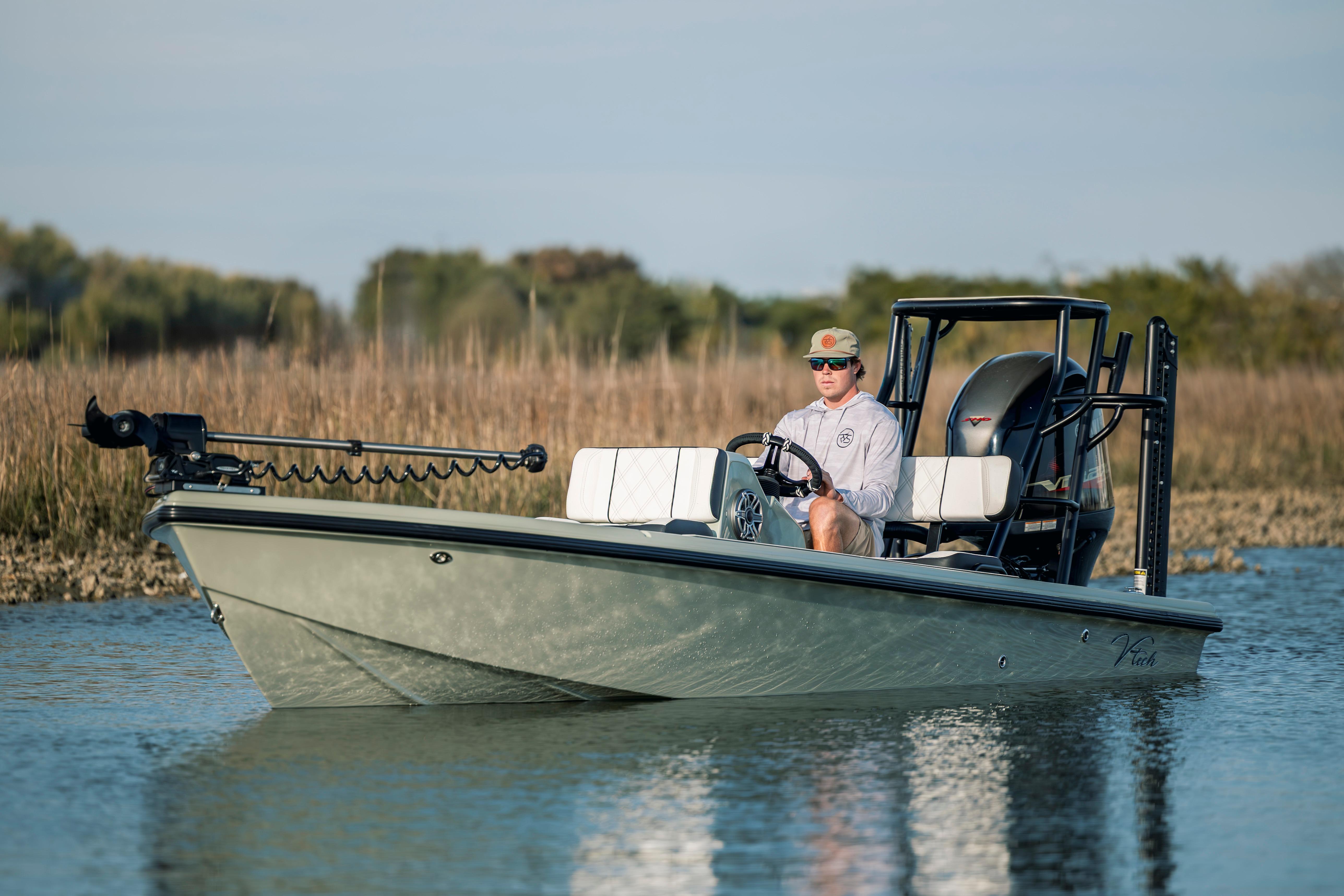 Man operating a 2025 Vtech 18 boat on a calm lake.