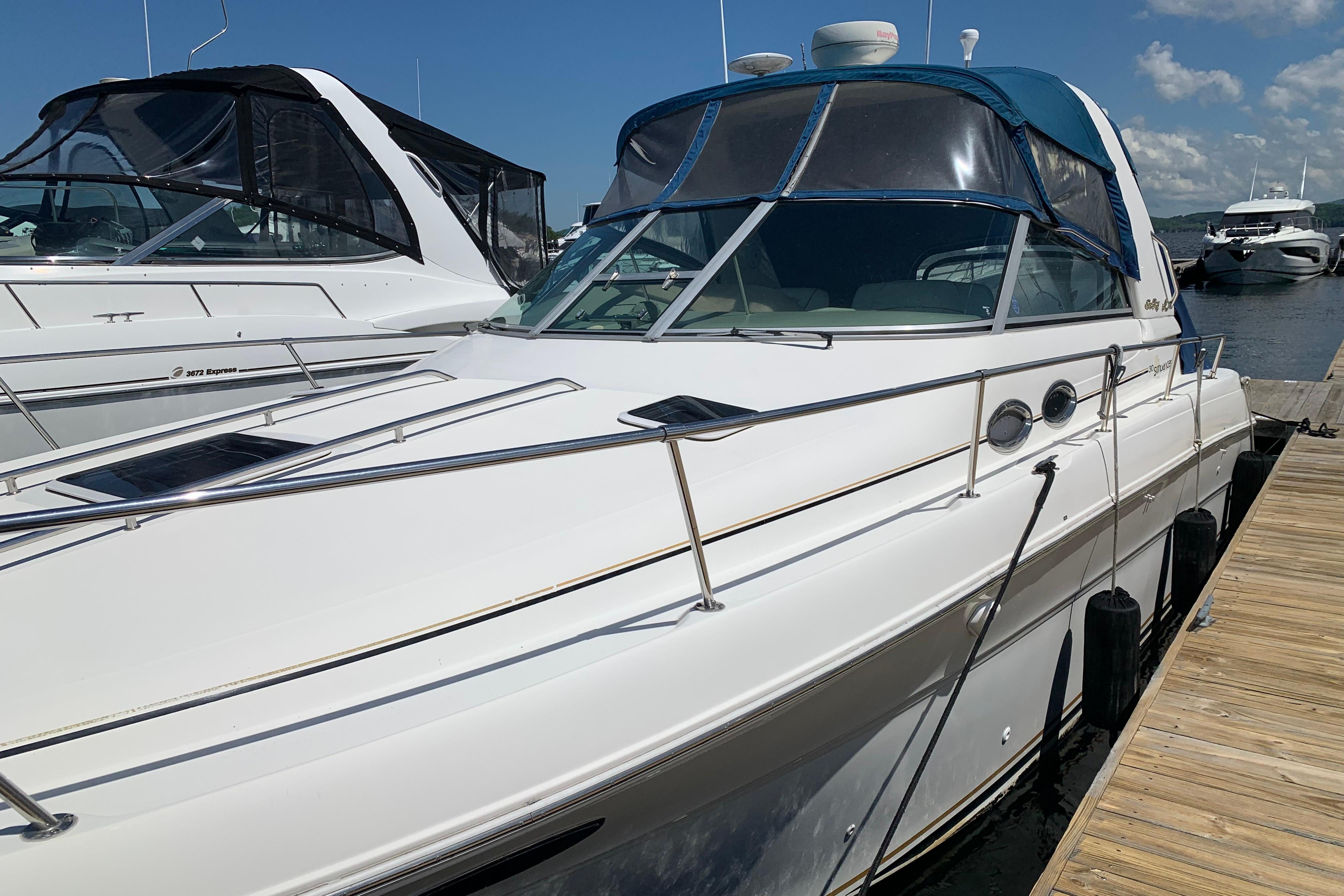 2000 Sea Ray Sundancer 310 docked at marina under clear blue sky.