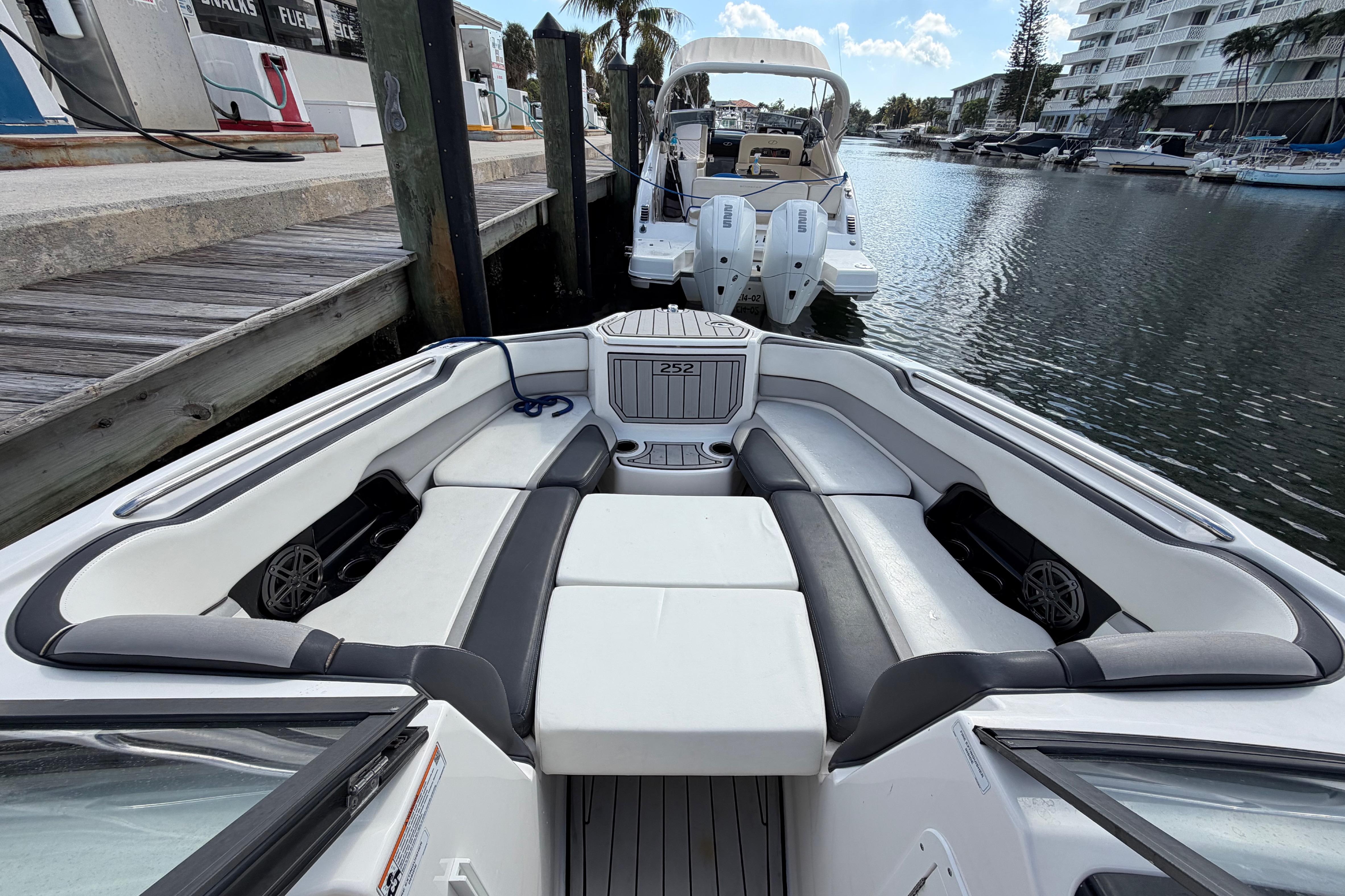 2022 Yamaha Boats 252SD interior, docked in a marina with luxurious seating.