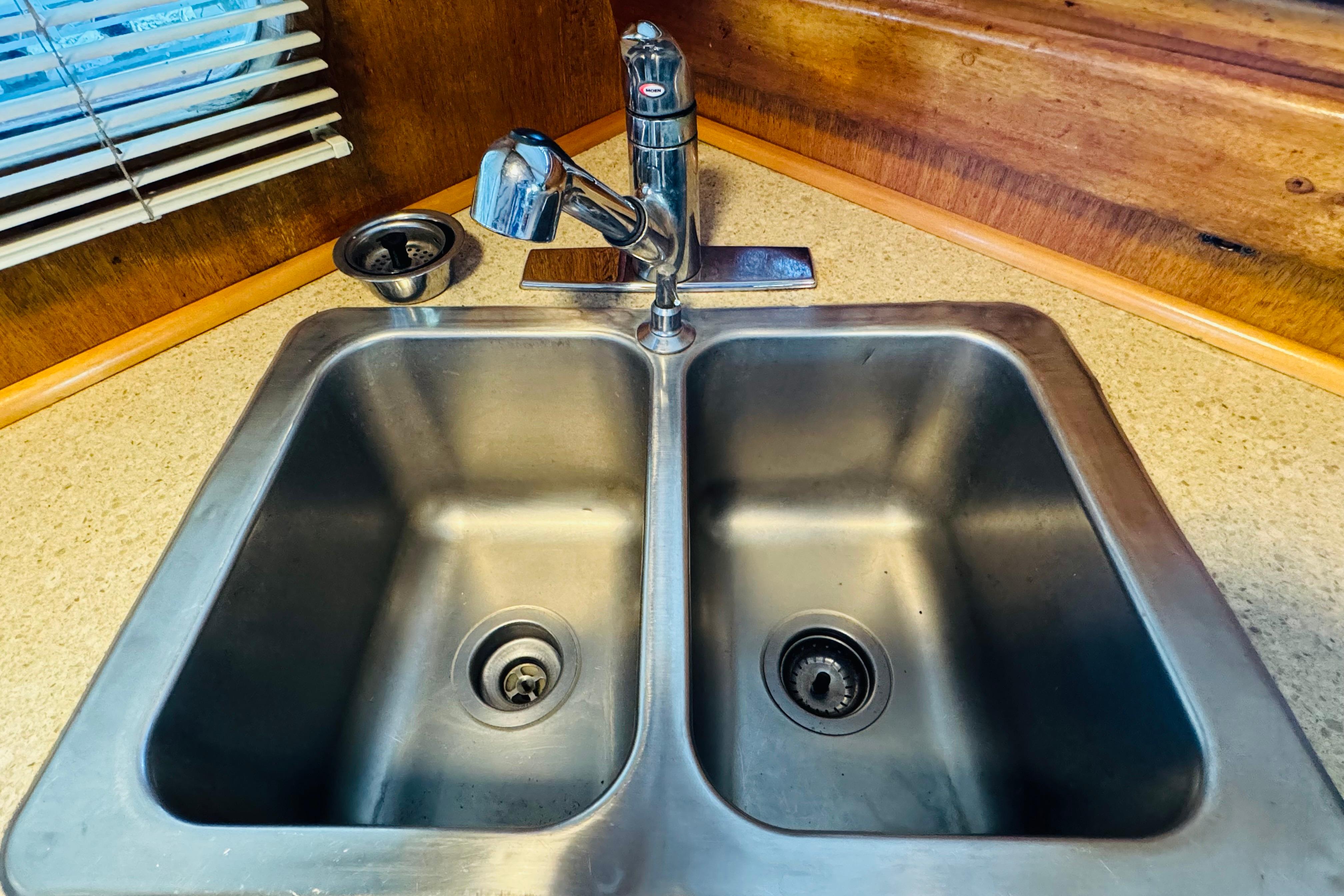 Stainless steel double sink with modern faucet in 1978 Californian 42 LRC boat kitchen.