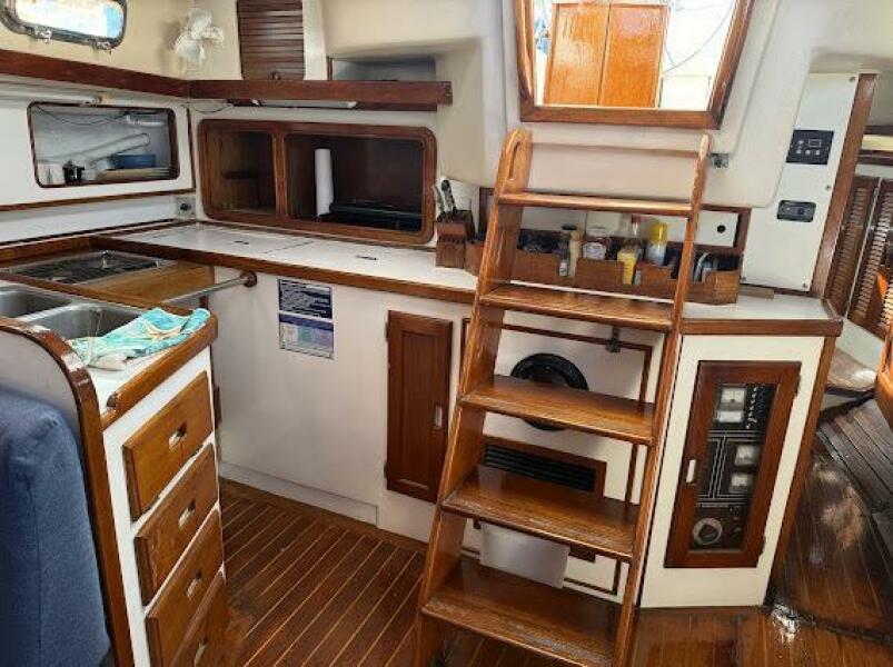 Interior of 1989 Catalina Morgan 440 sailboat, featuring wooden cabinetry and stairs.