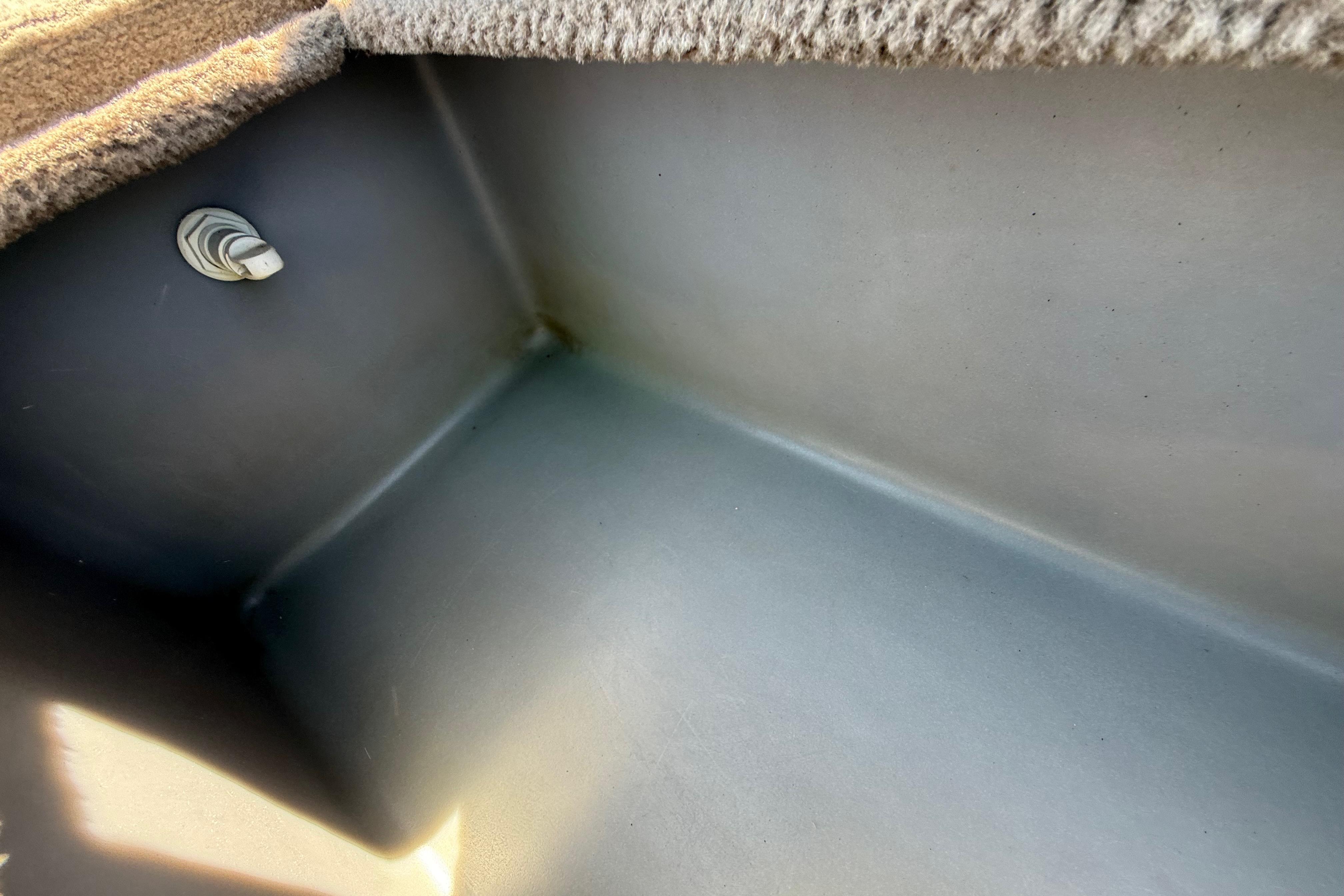 Interior view of a 2010 SeaArk Stealth 190 boat compartment with carpeted edge.