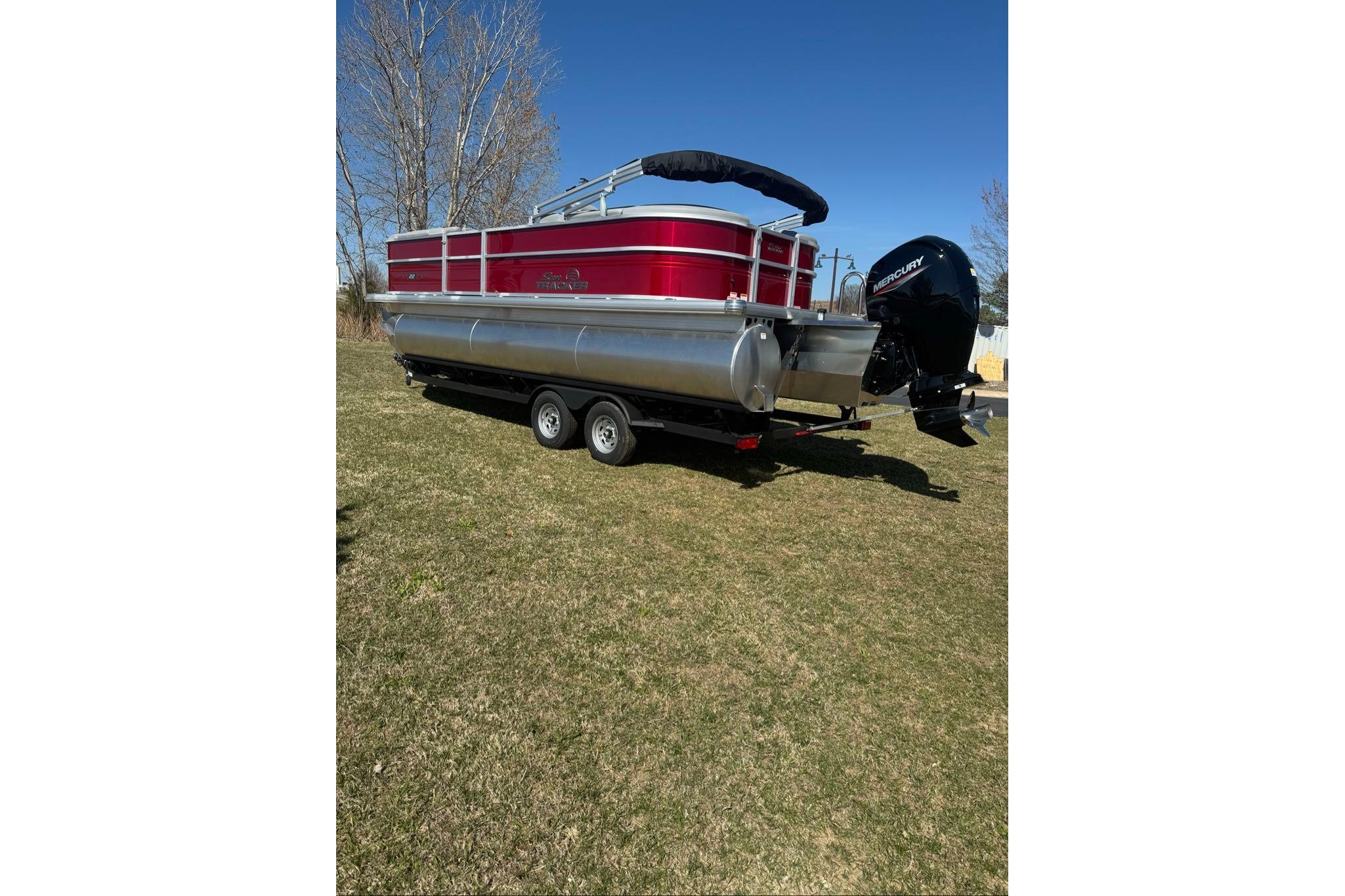 2026 Sun Tracker Party Barge 22 XP3 pontoon boat on grass, rear view.