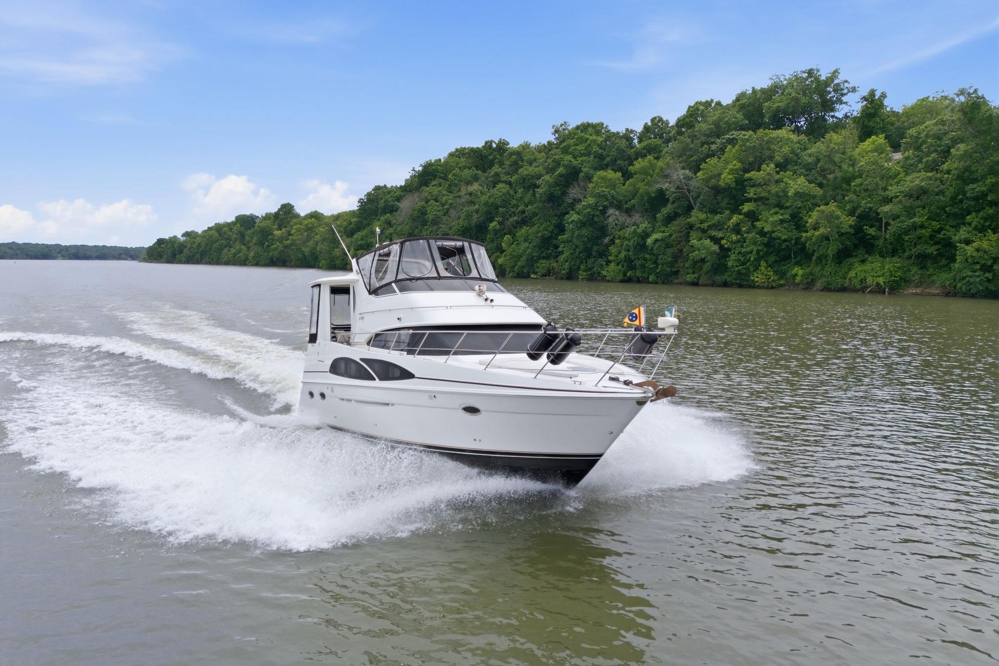 2005 Carver 39 Motor Yacht cruising on a scenic river with lush green trees.