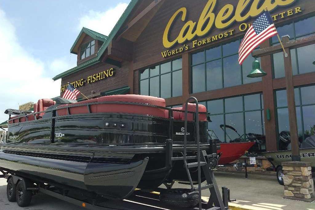 2026 Regency 230 DL boat displayed outside Cabela's store with American flags.