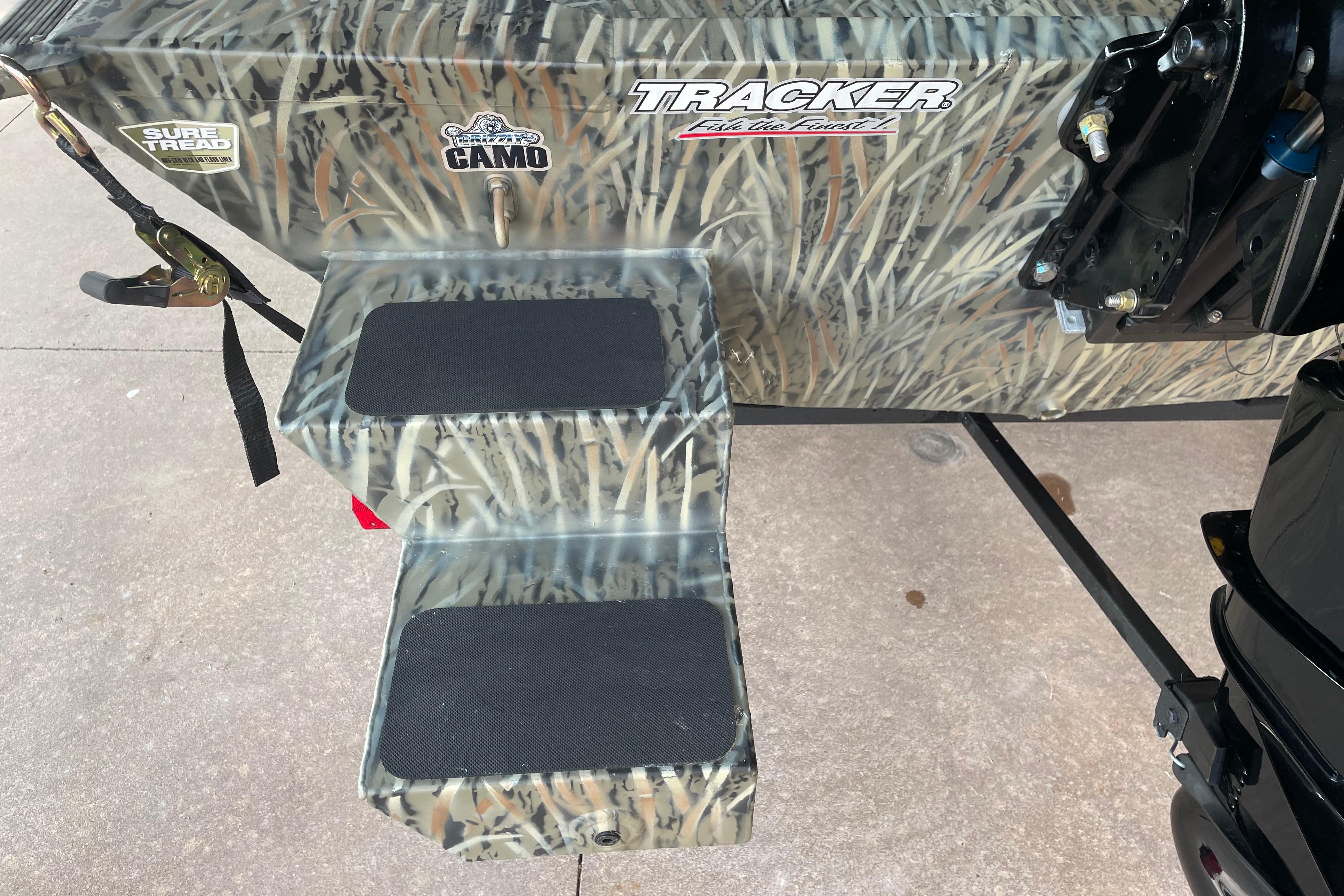 Camouflage-patterned Tracker Grizzly 1654 T Sportsman 2026 boat with Sure Tread steps.