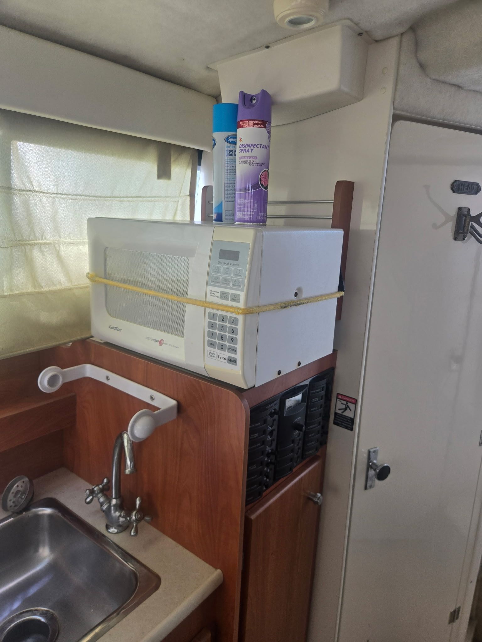 Kitchen area in a 2003 Bayliner 28 with microwave and sink.
