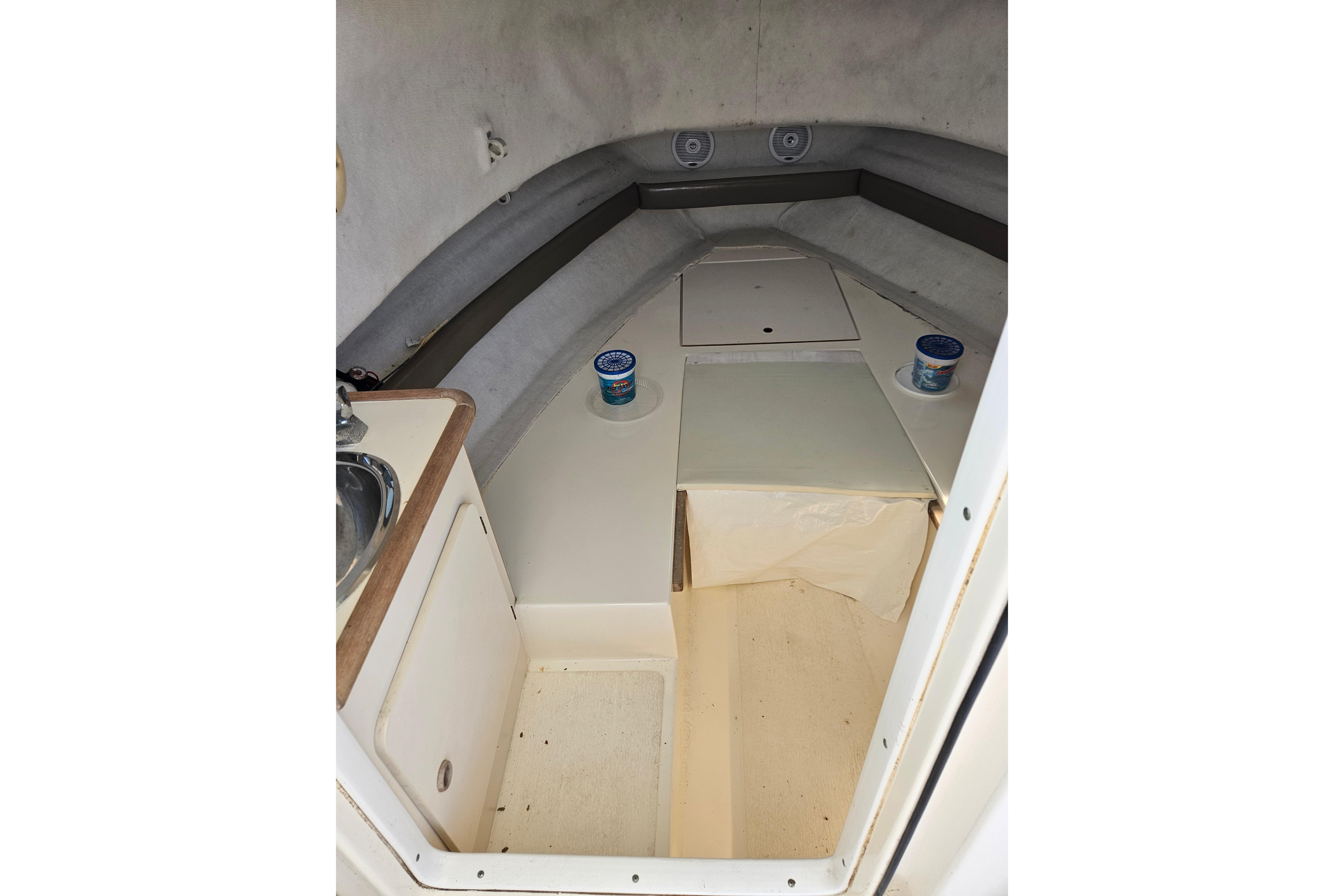 2004 Pursuit 2470 Walkaround cabin interior with sink and storage compartments.