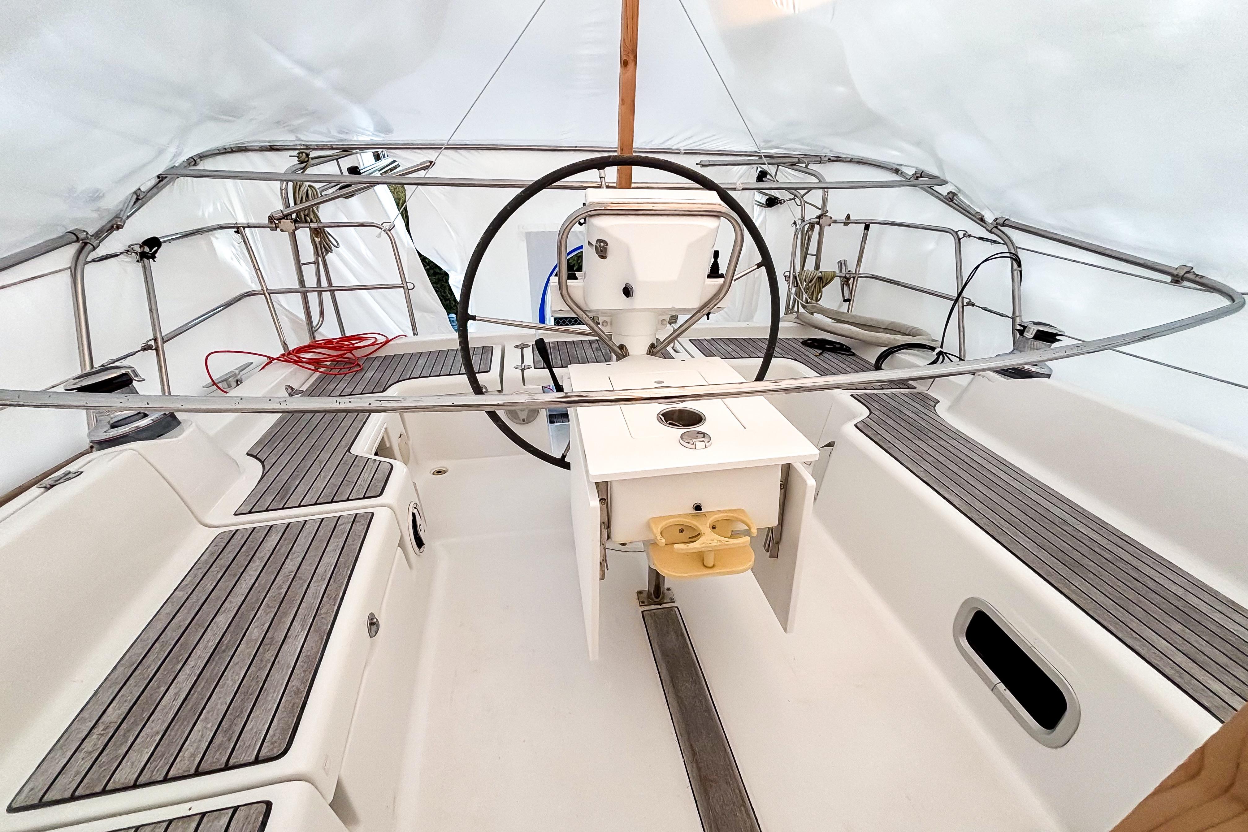 Cockpit of 2015 Beneteau Oceanis 37 sailboat with steering wheel and seating.