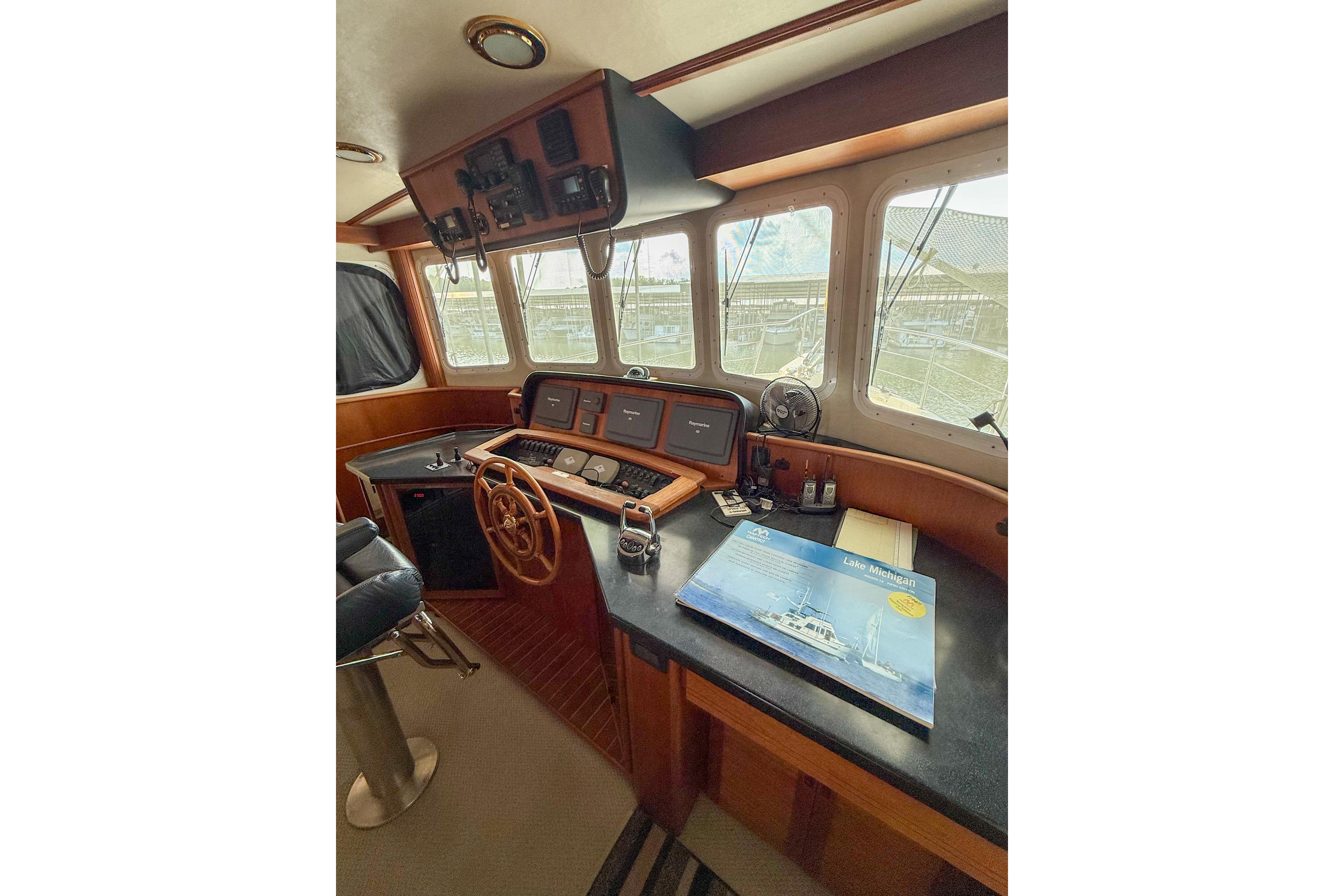 Pilothouse of 2007 Nordic Tug 54 with navigation equipment and large windows.