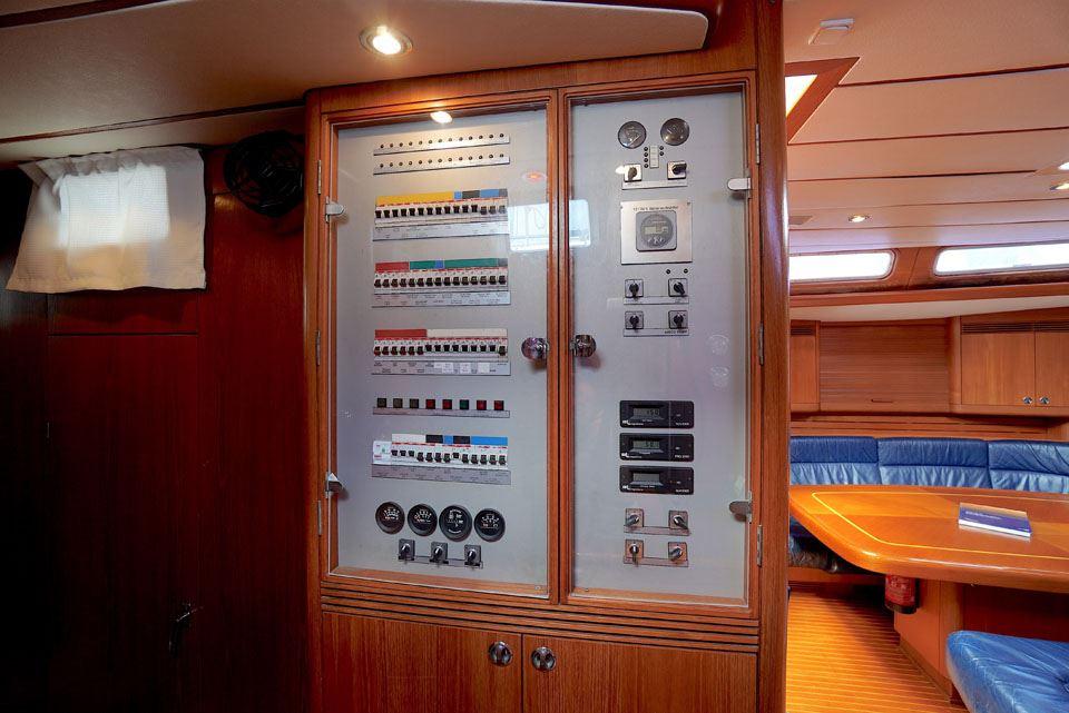 Control panel inside 1995 Nautor Swan 60 yacht, featuring wood interior and blue seating.