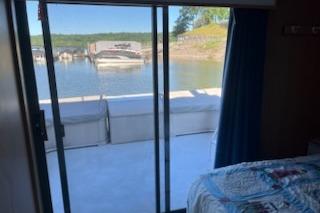 View from inside a 1994 PlayCraft 5215 houseboat, overlooking a serene lakeside marina.